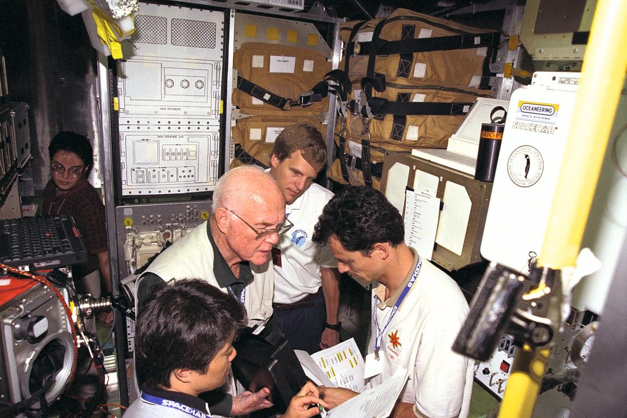 KENNEDY SPACE CENTER, FLA. -- STS-95 crew members review procedures in the SPACEHAB trainer at the SPACEHAB Payload Processing Facility in Cape Canaveral. From left, are Payload Specialists Chiaki Mukai and John H. Glenn Jr., and Mission Specialists Scott E. Parazynski and Pedro Duque. STS-95 will feature a variety of research payloads, including the Spartan solar-observing deployable spacecraft, the Hubble Space Telescope Orbital Systems Platform, the International Extreme Ultraviolet Hitchhiker, and experiments on space flight and the aging process. STS-95 is targeted for an Oct. 29 launch aboard the Space Shuttle Discovery