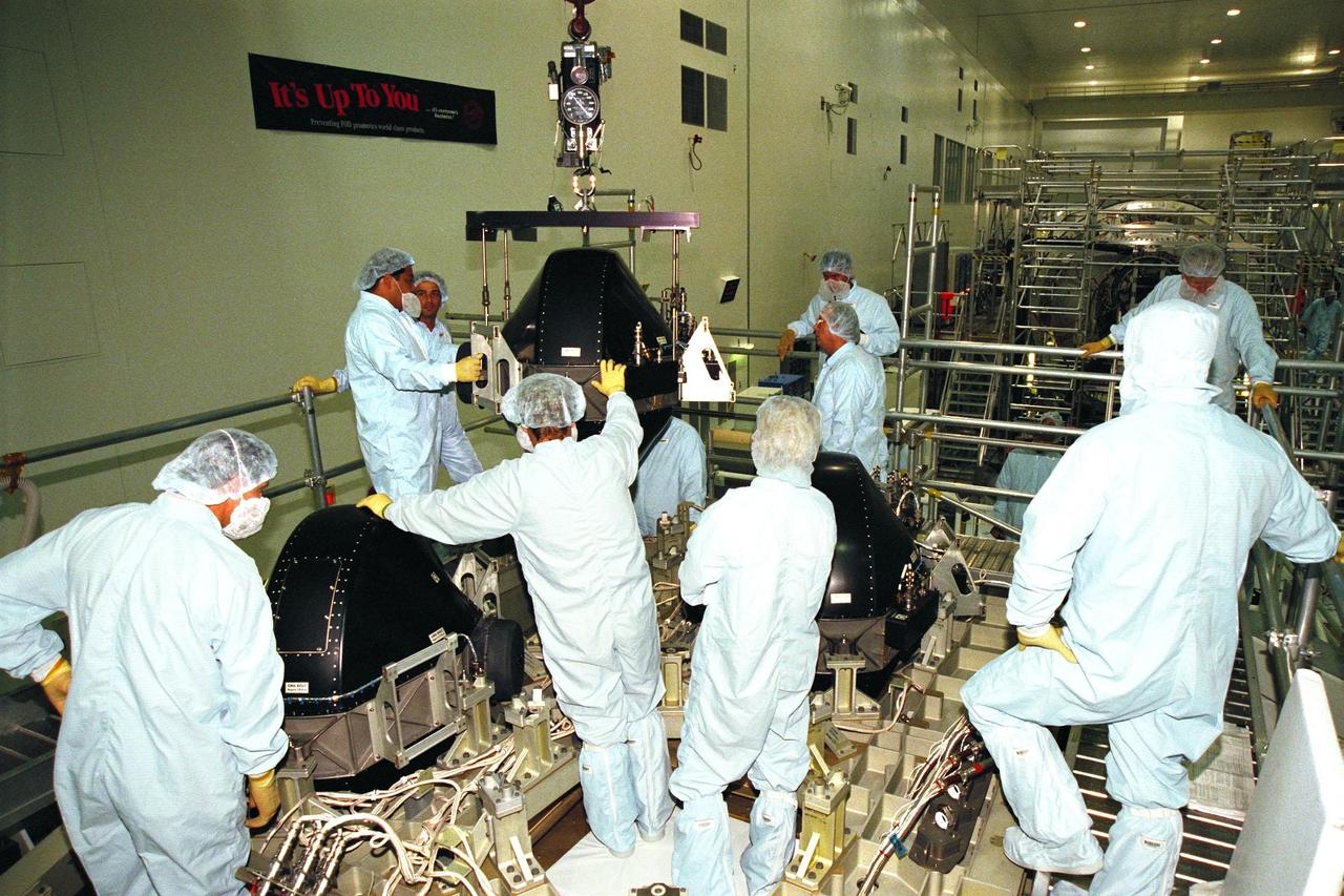 Boeing technicians lower a Control Moment Gyroscope (CMG) into place on the Integrated Truss Structure (ITS) Z1 in the Space Station Processing Facility at KSC. Gyroscopes are used for stabilization of the International Space Station (ISS). The CMG and Z1, part of the construction of the ISS, will be carried on STS-92, the third U.S. flight planned for on-orbit construction of the ISS. STS-92 is scheduled for liftoff on June 17, 1999, aboard the Space Shuttle Atlantis