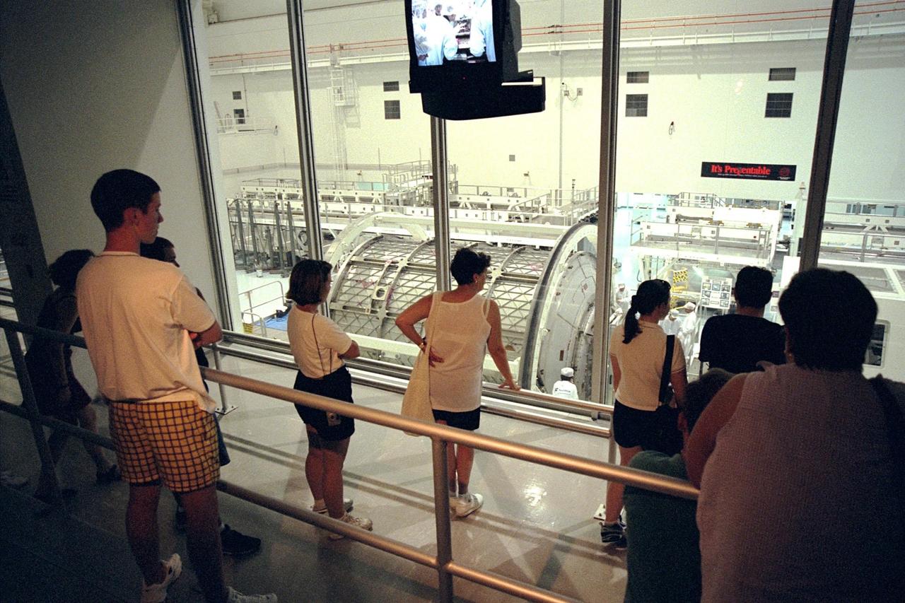 Visitors watch processing of the first Multi-Purpose Logistics Module (MPLM) for the International Space Station (ISS) from a new tour stop in the Space Station Processing Facility. The Italian-built module, named Leonardo, is one of three from Alenia Aerospazio, and will be operated by NASA and supported by ASI, the Italian space agency. The MPLMs will be carried in the payload bay of a Shuttle orbiter, and will provide storage and additional work space for up to two astronauts when docked to the ISS. Leonardo is scheduled to be launched on STS-100 in December 1999. The second MPLM, named Raffaello, is scheduled to be handed over in April 1999. A third module, to be named Donatello, is due to be delivered in October 2000 for launch in January 2001