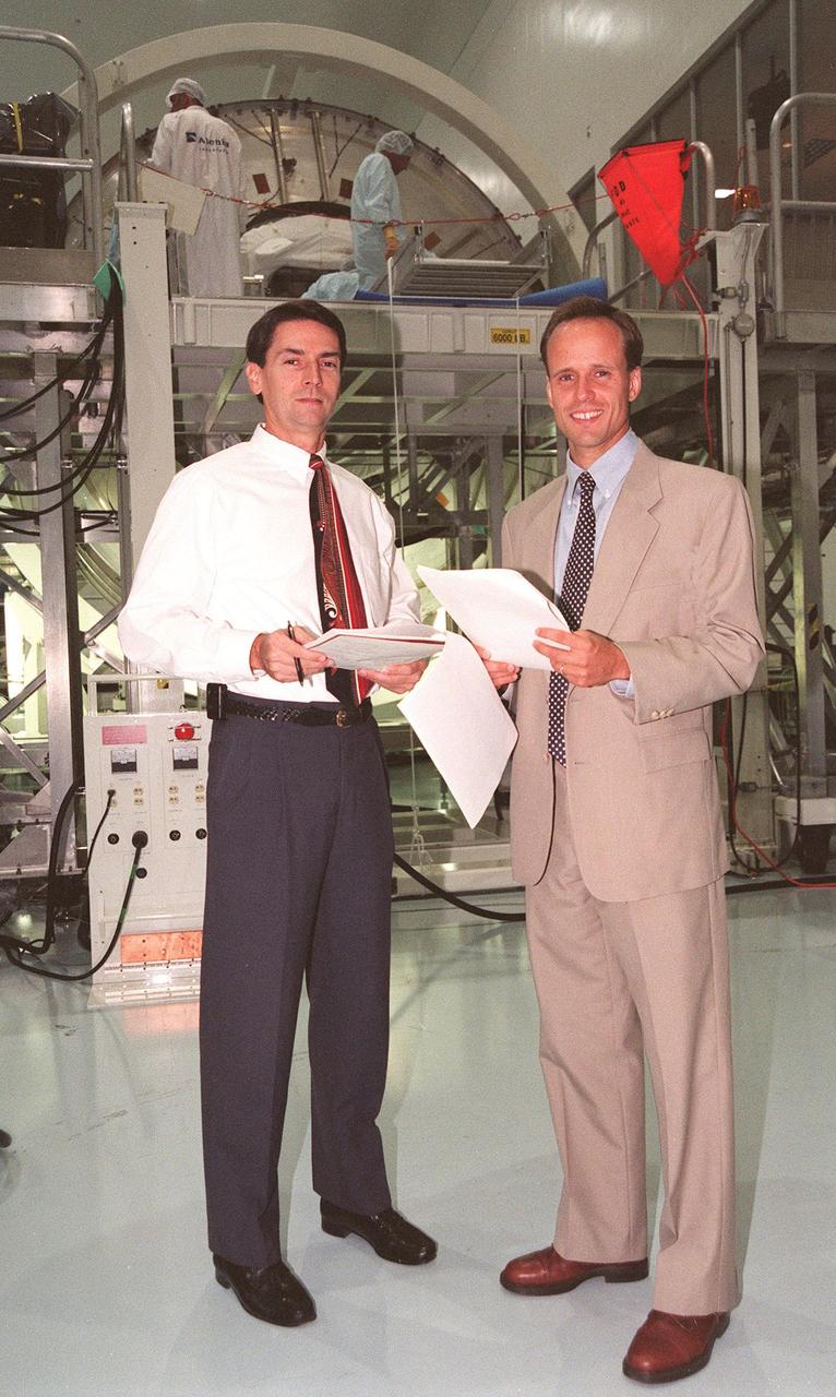 Michael Kinnan (left), with International Space Station (ISS) Launch Site Integration Office, and Todd McIntyre, with ISS International Elements, review paperwork for the Multi-Purpose Logistics Module (MPLM) in the Space Station Processing Facility at KSC. The Italian-built module, named Leonardo, is one of three to be provided by Alenia Aerospazio, and will be operated by NASA and supported by ASI, the Italian space agency. In the background, technicians from The Boeing Company and Alenia Aerospazio are preparing the first MPLM for flight. The MPLMs will be carried in the payload bay of a Shuttle orbiter, and will provide storage and additional work space for up to two astronauts when docked to the ISS. Leonardo is scheduled to be launched on STS-100 in December 1999. The second MPLM, named Raffaello, is scheduled to be handed over in April 1999. A third module, to be named Donatello, is due to be delivered in October 2000 for launch in January 2001