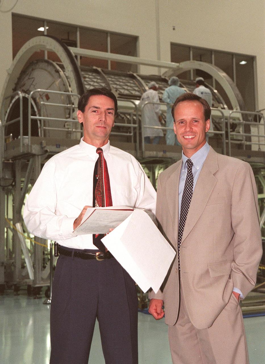 Michael Kinnan (left), with International Space Station (ISS) Launch Site Integration Office, and Todd McIntyre, with ISS International Elements, review paperwork for the Multi-Purpose Logistics Module (MPLM) in the Space Station Processing Facility at KSC. The Italian-built module, named Leonardo, is one of three to be provided by Alenia Aerospazio, and will be operated by NASA and supported by ASI, the Italian space agency. In the background, technicians from The Boeing Company and Alenia Aerospazio are preparing the first MPLM for flight. The MPLMs will be carried in the payload bay of a Shuttle orbiter, and will provide storage and additional work space for up to two astronauts when docked to the ISS. Leonardo is scheduled to be launched on STS-100 in December 1999. The second MPLM, named Raffaello, is scheduled to be handed over in April 1999. A third module, to be named Donatello, is due to be delivered in October 2000 for launch in January 2001
