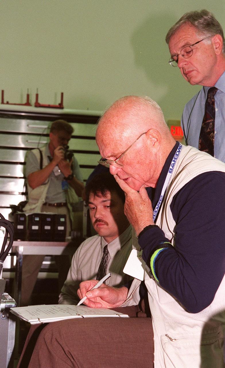 KENNEDY SPACE CENTER, FLA. -- STS-95 Payload Specialist John Glenn, who is a senator from Ohio, looks over documentation under the watchful eyes of KSC workers during SPACEHAB familiarization at the SPACEHAB Payload Processing Facility, Cape Canaveral. The mission, scheduled to launch Oct. 29, includes research payloads such as the Spartan solar-observing deployable spacecraft, the Hubble Space Telescope Orbital Systems Test Platform, the International Extreme Ultraviolet Hitchhiker, as well as the SPACEHAB single module with experiments on space flight and the aging process