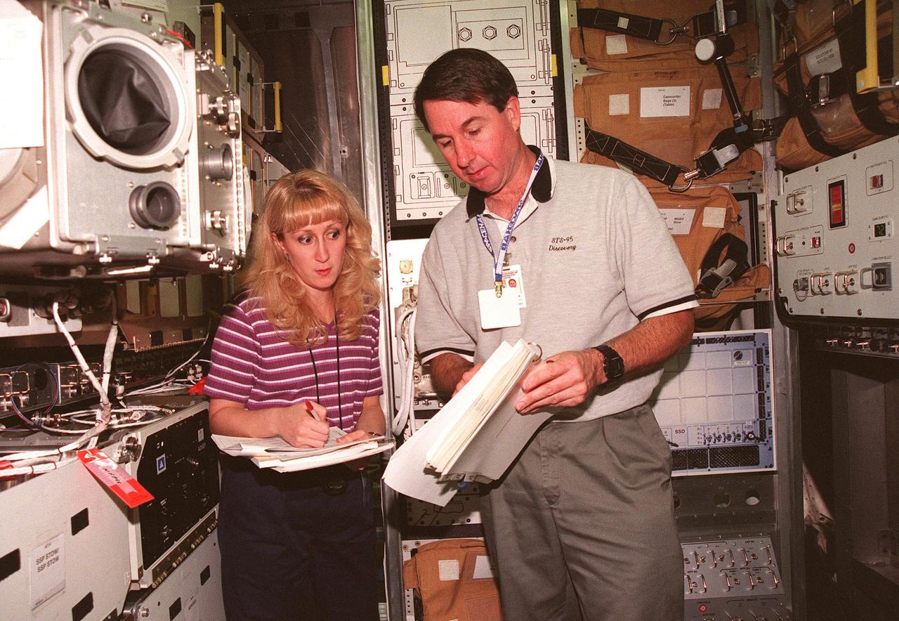 KENNEDY SPACE CENTER, FLA. -- Terri Schneider, a Timeline technician with United Space Alliance, and STS-95 Mission Specialist Stephen Robinson, Ph.D., look at documentation during SPACEHAB familiarization at the SPACEHAB Payload Processing Facility, Cape Canaveral. The mission, scheduled to launch Oct. 29, includes research payloads such as the Spartan solar-observing deployable spacecraft, the Hubble Space Telescope Orbital Systems Test Platform, the International Extreme Ultraviolet Hitchhiker, as well as the SPACEHAB single module with experiments on space flight and the aging process
