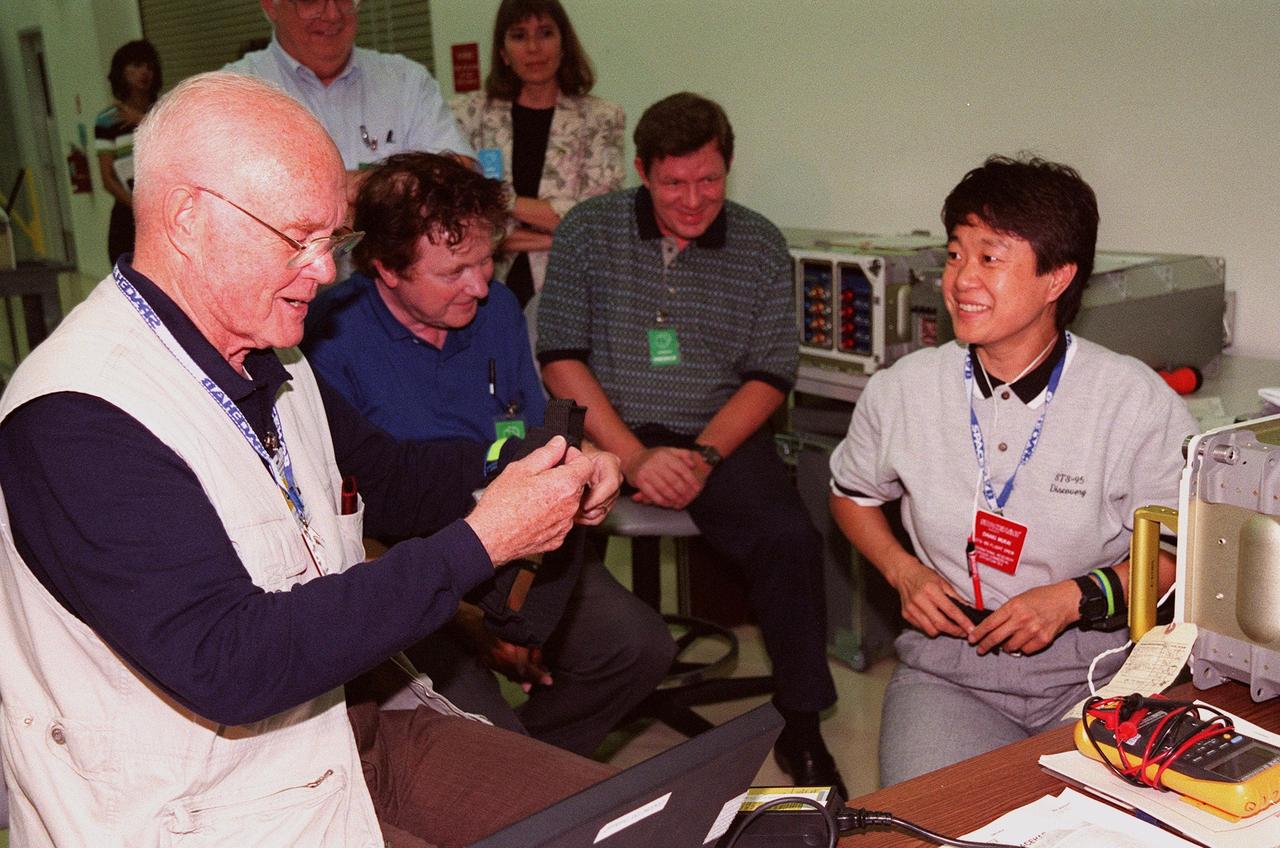 KENNEDY SPACE CENTER, FLA. -- STS-95 Payload Specialist John Glenn (left), who is a senator from Ohio, and Payload Specialist Chiaki Mukai (extreme right), who represents the National Space Development Agency of Japan (NASDA), check out equipment during SPACEHAB familiarization at the SPACEHAB Payload Processing Facility, Cape Canaveral. KSC workers in the background observe. The mission, scheduled to launch Oct. 29, includes research payloads such as the Spartan solar-observing deployable spacecraft, the Hubble Space Telescope Orbital Systems Test Platform, the International Extreme Ultraviolet Hitchhiker, as well as the SPACEHAB single module with experiments on space flight and the aging process