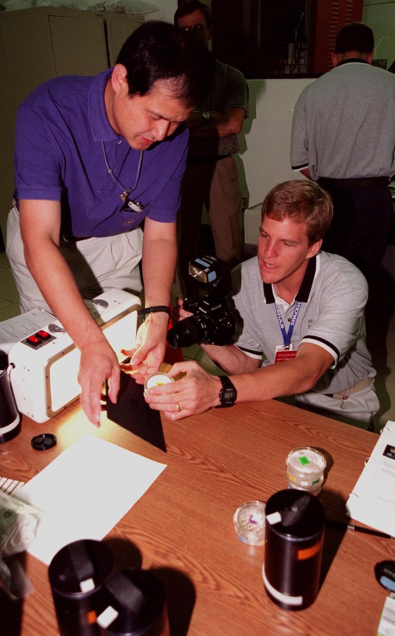 KENNEDY SPACE CENTER, FLA. -- In the SPACEHAB Payload Processing Facility (SPPF) a representative of the National Space Agency of Japan (NASDA) and STS-95 Mission Specialist Scott Parazynski, M.D. (right), check out BRIC (Biological Research in Canisters) experiments to be part of the mission scheduled to launch Oct. 29. STS-95 crew members have been participating in SPACEHAB familiarization in the SPPF. The mission includes research payloads such as the Spartan solar-observing deployable spacecraft, the Hubble Space Telescope Orbital Systems Test Platform, the International Extreme Ultraviolet Hitchhiker, as well as the SPACEHAB single module with experiments on space flight and the aging process