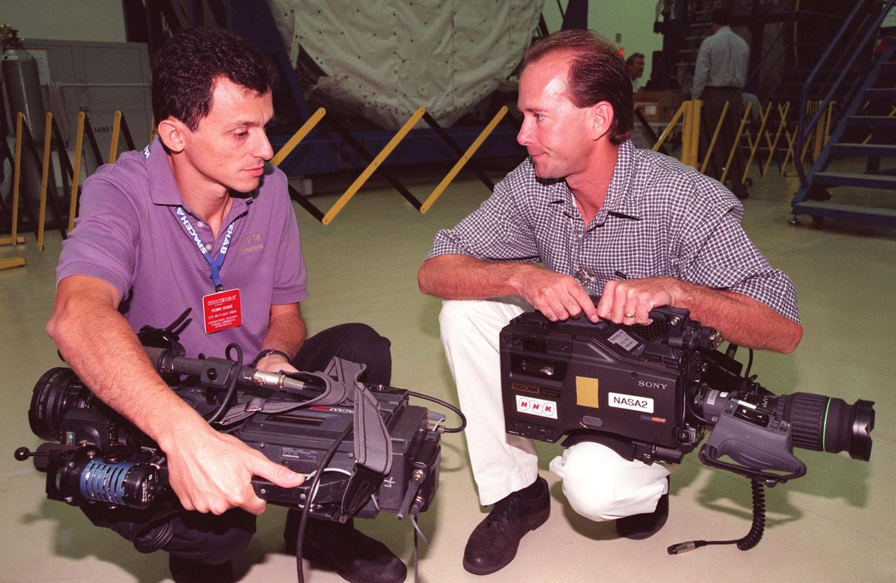 KENNEDY SPACE CENTER, FLA. -- STS-95 Mission Specialist Pedro Duque (left) of Spain, who represents the European Space Agency (ESA), talks to KSC photographer Glen Benson in the SPACEHAB Payload Processing Facility (SPPF) about video cameras to be used on the mission. STS-95 crew members have been participating in SPACEHAB familiarization in the SPPF. Scheduled to launch Oct. 29, the mission includes research payloads such as the Spartan solar-observing deployable spacecraft, the Hubble Space Telescope Orbital Systems Test Platform, the International Extreme Ultraviolet Hitchhiker, as well as the SPACEHAB single module with experiments on space flight and the aging process