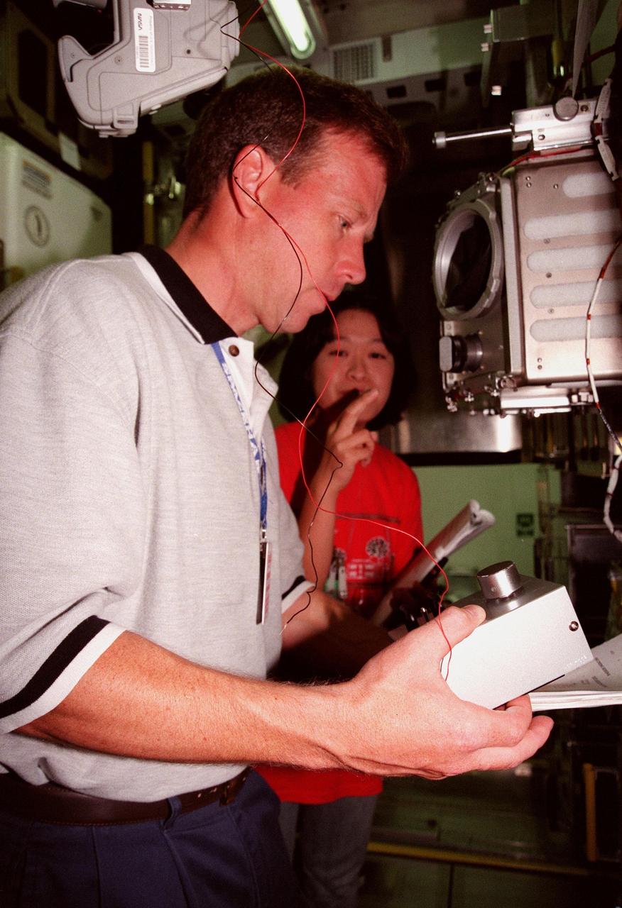 KENNEDY SPACE CENTER, FLA. -- STS-95 Pilot Stephen Lindsey checks out equipment in the SPACEHAB Payload Processing Facility (SPPF), Cape Canaveral, while a representative of the National Space Development Agency of Japan (NASDA) watches. STS-95 crew members have been participating in SPACEHAB familiarization in the SPPF. Scheduled to launch Oct. 29, the mission includes research payloads such as the Spartan solar-observing deployable spacecraft, the Hubble Space Telescope Orbital Systems Test Platform, the International Extreme Ultraviolet Hitchhiker, as well as the SPACEHAB single module with experiments on space flight and the aging process