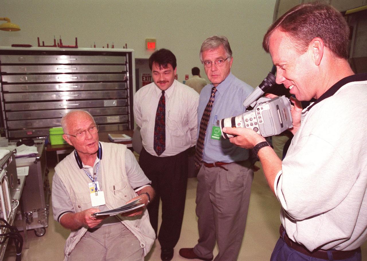 KENNEDY SPACE CENTER, FLA. -- In the SPACEHAB Payload Processing Facility (SPPF), Cape Canaveral, STS-95 Payload Specialist John Glenn, who is a senator from Ohio, is a willing subject for Pilot Steven Lindsey, who practices his camera technique while KSC workers watch. STS-95 crew members have been participating in SPACEHAB familiarization in the SPPF. Scheduled to launch Oct. 29, the mission includes research payloads such as the Spartan solar-observing deployable spacecraft, the Hubble Space Telescope Orbital Systems Test Platform, the International Extreme Ultraviolet Hitchhiker, as well as the SPACEHAB single module with experiments on space flight and the aging process
