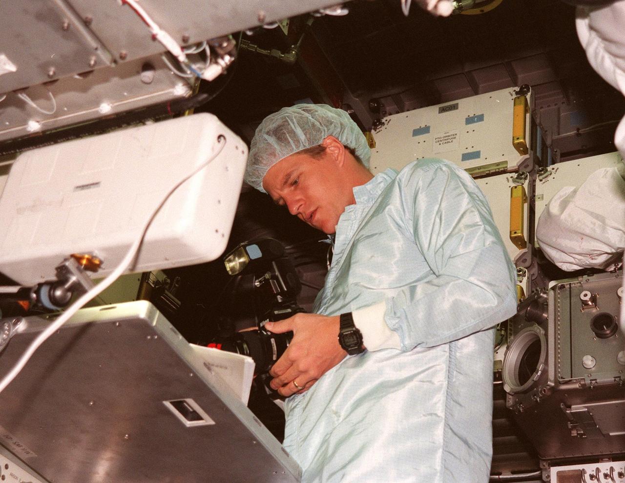 KENNEDY SPACE CENTER, FLA. -- Inside the SPACEHAB in the SPACEHAB Payload Processing Facility (SPPF), STS-95 Mission Specialist Scott Parazynski, M.D., checks out a camera, part of the equipment to fly on the mission scheduled to launch Oct. 29. He and other STS-95 crew members have been participating in SPACEHAB familiarization in the SPPF. The mission includes research payloads such as the Spartan solar-observing deployable spacecraft, the Hubble Space Telescope Orbital Systems Test Platform, the International Extreme Ultraviolet Hitchhiker, as well as the SPACEHAB single module with experiments on space flight and the aging process