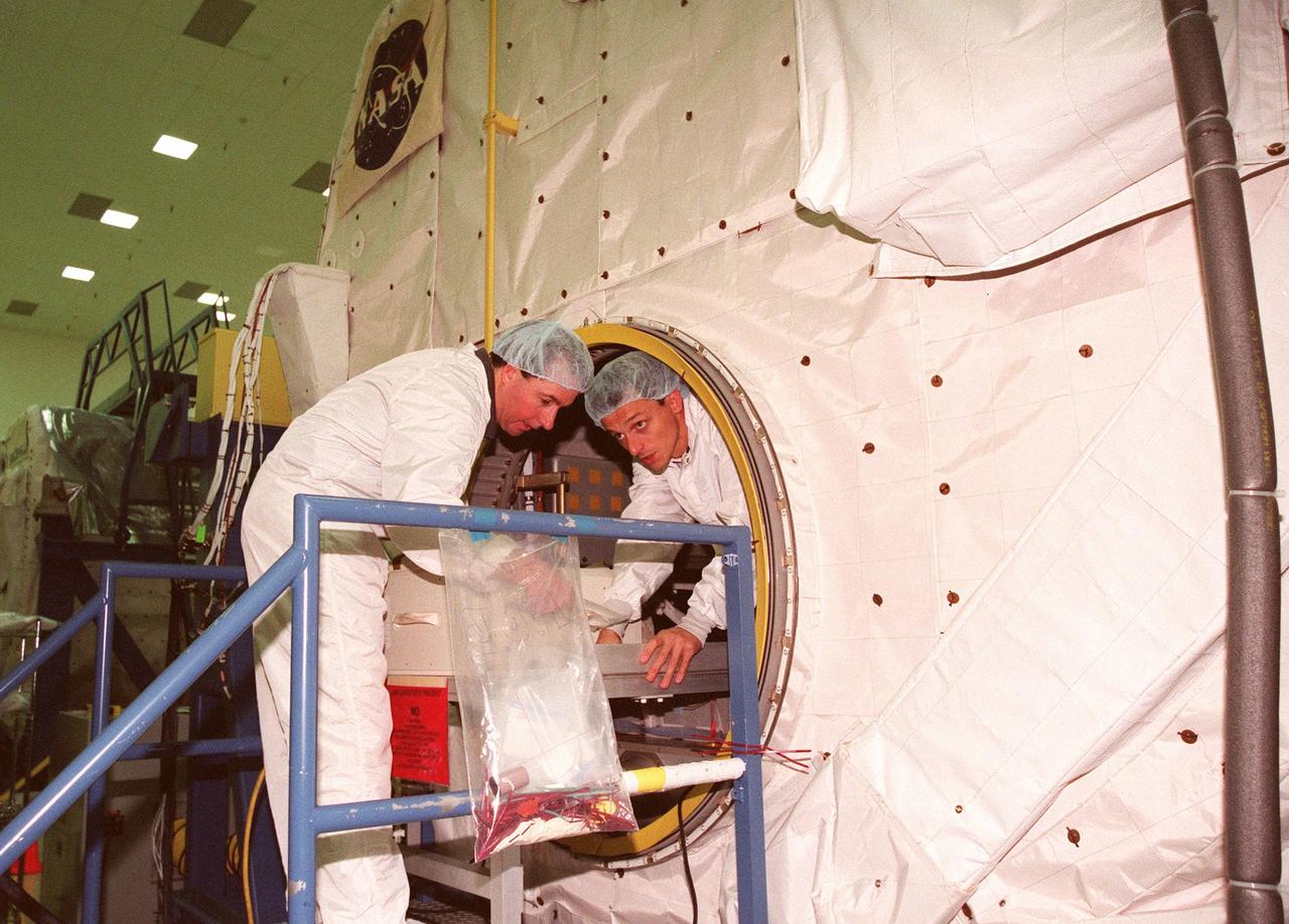 KENNEDY SPACE CENTER, FLA. -- STS-95 Mission Specialist Stephen Robinson, Ph.D., (left) and Mission Specialist Pedro Duque (right) of Spain, who represents the European Space Agency (ESA), enter the SPACEHAB in the SPACEHAB Payload Processing Facility (SPPF). STS-95 crew members have been participating in SPACEHAB familiarization in the SPPF. Scheduled to launch Oct. 29, the mission includes research payloads such as the Spartan solar-observing deployable spacecraft, the Hubble Space Telescope Orbital Systems Test Platform, the International Extreme Ultraviolet Hitchhiker, as well as the SPACEHAB single module with experiments on space flight and the aging process