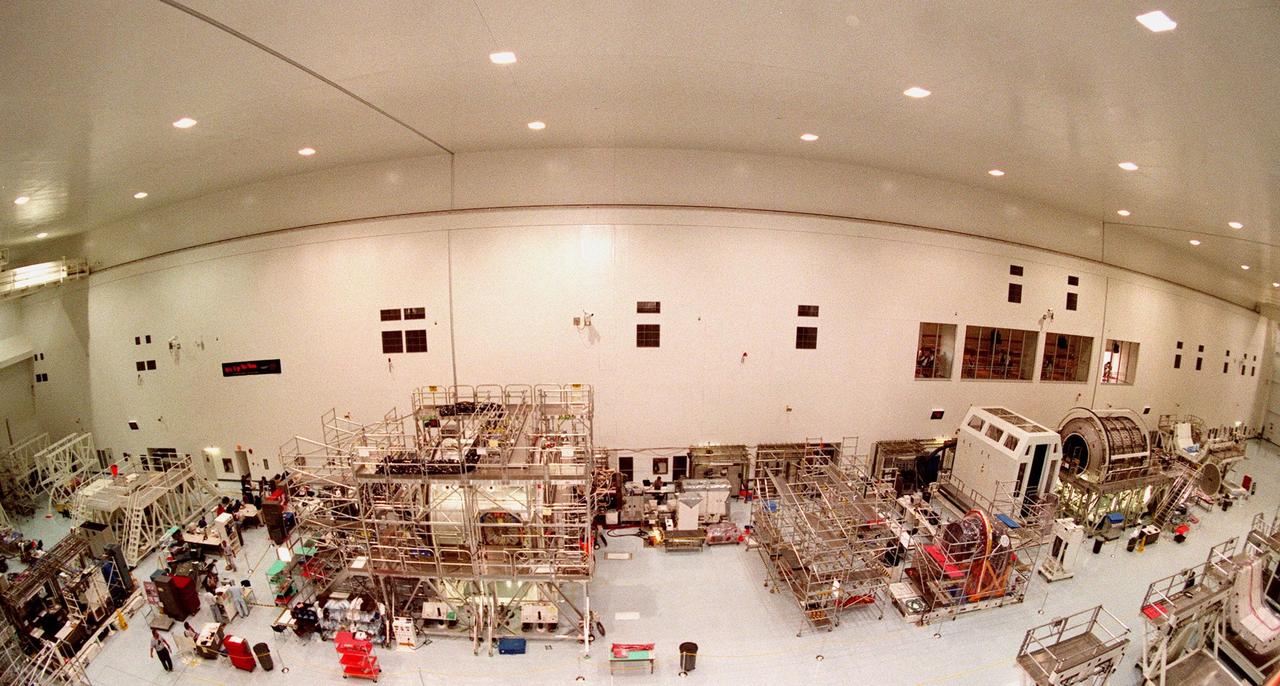 KENNEDY SPACE CENTER, FLA. -- In this panoramic view of the Space Station Processing Facility (SSPF) can be seen (left to right) Unity connecting module, the Rack Insertion Device and the first Multi-Purpose Launch Module, the Leonardo. Windows at the right above Leonardo allow visitors on tour to watch the activities in the SSPF. The Unity, scheduled to be launched on STS-88 in December 1998, will be mated to the Russian-built Zarya control module which will already be in orbit. STS-88 will be the first Space Shuttle launch for the International Space Station. The Italian-built MPLM, scheduled to be launched on STS-100 on Dec. 2, 1999, will be carried in the payload bay of the Shuttle orbiter, and will provide storage and additional work space for up to two astronauts when docked to the International Space Station
