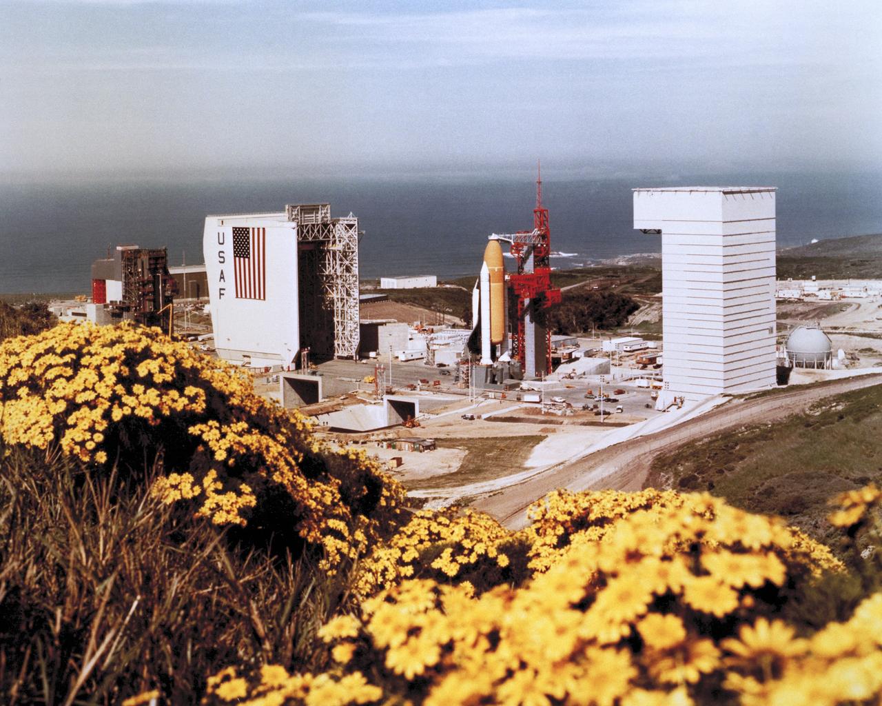 VANDENBERG AIR FORCE BASE, Calif. -- At Vandenberg Air Force Base in the early '80s, the Space Shuttle Enterprise undergoes Pathfinder fit checks at a tower. The Enterprise was built as a test vehicle and was not equipped for spaceflight.  Enterprise eventually became the property of the Smithsonian Institution.      Vandenberg AFB is located on the Central Coast of California about 150 miles northwest of Los Angeles. The property is comprised of parts of five Mexican land grants and a sixth grant that was transferred virtually intact to the Army.  Vandenberg now is operated by the 30th Space Wing, and is the only military installation in the United States from which unmanned government and commercial satellites are launched into polar orbit. It is also the only site from which intercontinental ballistic missiles ICBMs are launched toward the Kwajalein Atoll to verify weapon systems performance. Vandenberg's military service dates back to 1941, when known as Camp Cooke it served as an Army training facility for armored and infantry troops. The main camp closed in June 1946 and was reactivated in August 1950 after the outbreak of the Korean War. The 13th and 20th Armored Divisions and the 40th, 44th, 86th, and 91st Infantry Divisions trained at Cooke. With the advent of the missile age in the 1950s, the Air Force persuaded Secretary of Defense Charles E. Wilson to direct the Army to transfer 64,000 acres of North Camp Cooke to the Air Force for use as a missile launch and training base. In 1958, Camp Cooke was renamed Vandenberg Air Force Base in honor of the late General Hoyt S. Vandenberg, second Air Force Chief of Staff of the United States Air Force and chief architect of today's modern Air Force.    Photo Credit: NASA