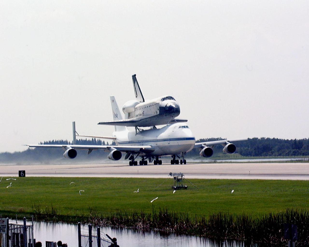 KENNEDY SPACE CENTER, FLA. -- At the Shuttle Landing Facility, egrets along the runway take flight as the orbiter Columbia leaves Kennedy Space Center on the back of a Boeing 747 Shuttle Carrier Aircraft on a ferry flight to Palmdale, Calif. Columbia, the oldest of four orbiters in NASA's fleet, will undergo extensive inspections and modifications in Boeing's Orbiter Assembly Facility during a nine-month orbiter maintenance down period (OMDP), the second in its history. Orbiters are periodically removed from flight operations for an OMDP. Columbia's first was in 1994. Along with more than 100 modifications on the vehicle, Columbia will be the second orbiter to be outfitted with the multifunctional electronic display system, or "glass cockpit." Columbia is expected to return to KSC in July 2000