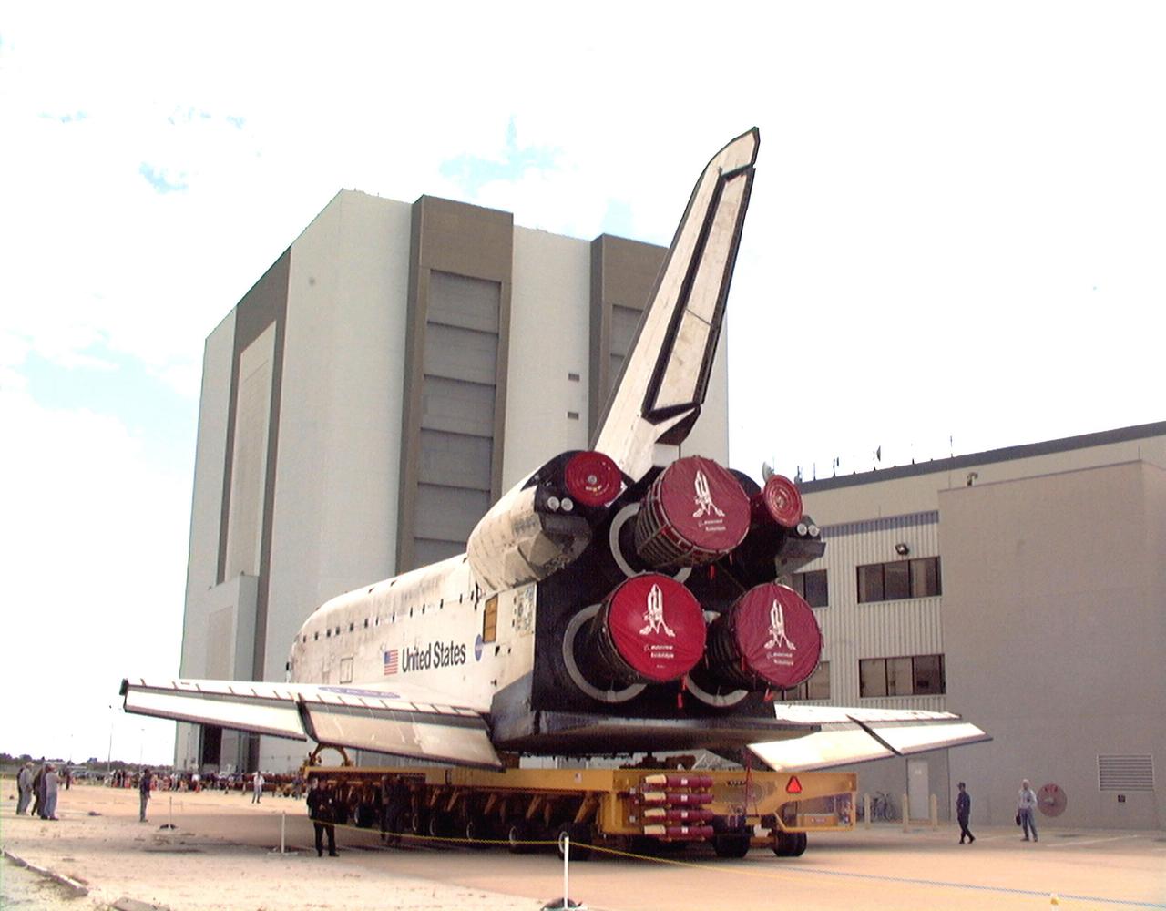 KENNEDY SPACE CENTER, FLA. -- Orbiter Discovery begins its rollover to the Vehicle Assembly Building (in the background) after leaving the Orbiter Processing Facility bay 1. Launch date for Discovery on mission STS-103, the third Hubble Space Telescope servicing mission, is under review for early December. The mission is a "call-up" due to the need to replace portions of the pointing system, the gyros, which have begun to fail on the Hubble Space Telescope. Although Hubble is operating normally and conducting its scientific observations, only three of its six gyroscopes are working properly. The gyroscopes allow the telescope to point at stars, galaxies and planets. The STS-103 crew will also be replacing a Fine Guidance Sensor and an older computer with a new enhanced model, an older data tape recorder with a solid-state digital recorder, a failed spare transmitter with a new one, and degraded insulation on the telescope with new thermal insulation. The crew will also install a Battery Voltage/Temperature Improvement Kit to protect the spacecraft batteries from overcharging and overheating when the telescope goes into a safe mode