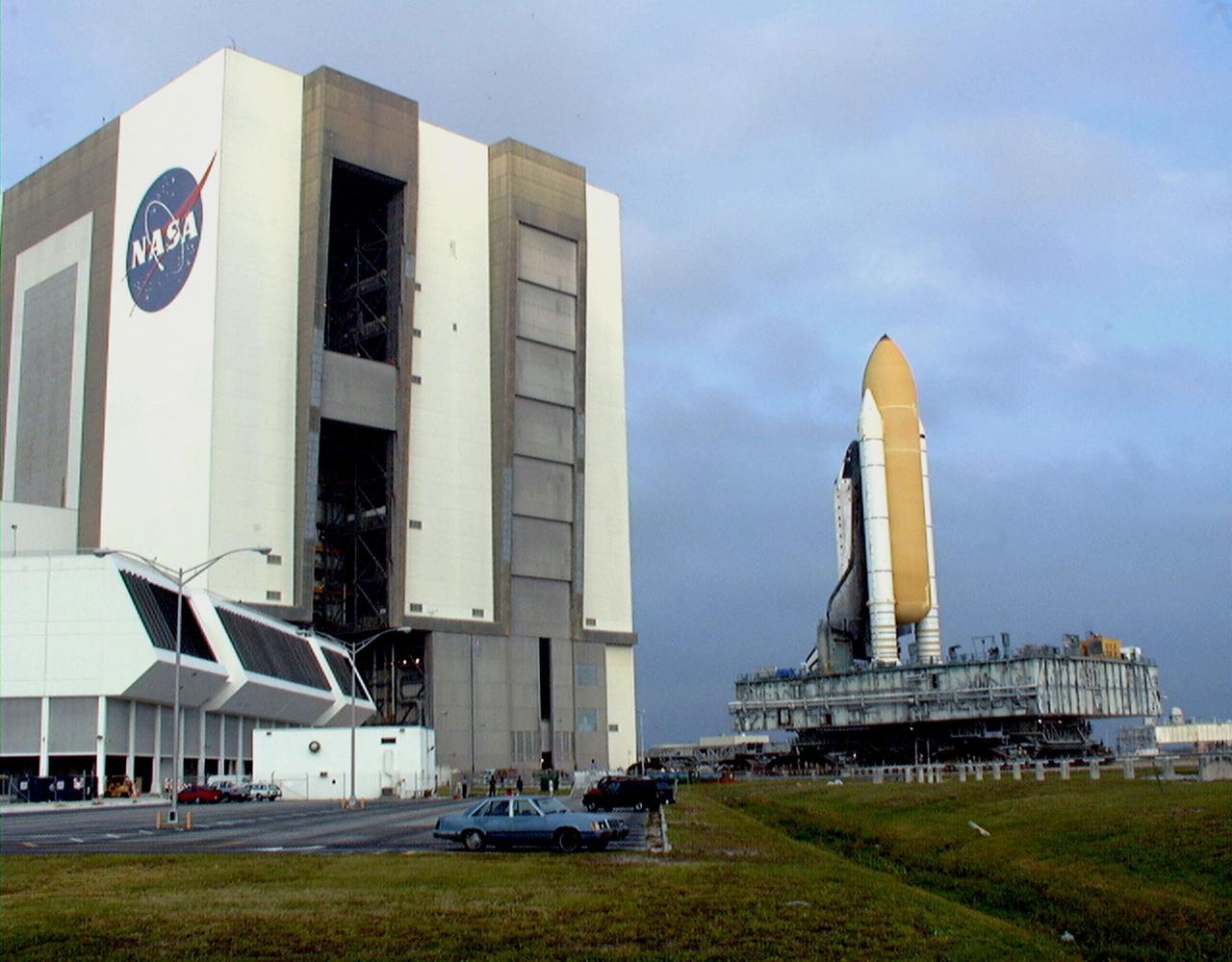 KENNEDY SPACE CENTER, FLA. -- Towering atop the mobile launcher platform and crawler transporter, Space Shuttle Discovery rolls out of the Vehicle Assembly Building on its way to Launch Pad 39B which is 4.2 miles (6.8 kilometers) away. While at the pad, the orbiter, external tank and solid rocket boosters will undergo final preparations for the STS-103 launch targeted for Dec. 6, 1999, at 2:37 a.m. EST. The mission is a "call-up" due to the need to replace portions of the pointing system the gyros which have begun to fail on the Hubble Space Telescope. Although Hubble is operating normally and conducting its scientific observations, only three of its six gyroscopes are working properly. The gyroscopes allow the telescope to point at stars, galaxies and planets. The STS-103 crew will also be installing a Fine Guidance Sensor, a new enhanced computer, a solid-state digital recorder, and a new spare transmitter to replace older equipment, and replacing degraded insulation on the telescope with new thermal insulation. The crew will also install a Battery Voltage/Temperature Improvement Kit to protect the spacecraft batteries from overcharging and overheating when the telescope goes into a safe mode. Four EVA's are planned to make the necessary repairs and replacements on the telescope. Comprising the STS-103 crew are Commander Curtis L. Brown Jr., Pilot Scott J. Kelly, Mission Specialist Steven L. Smith, Mission Specialist C. Michael Foale (Ph.D.), Mission Specialist John M. Grunsfeld (Ph.D.), Mission Specialist Claude Nicollier of Switzerland, with the European Space Agency, and Mission Specialist Jean-François Clervoy of France, with the European Space Agency