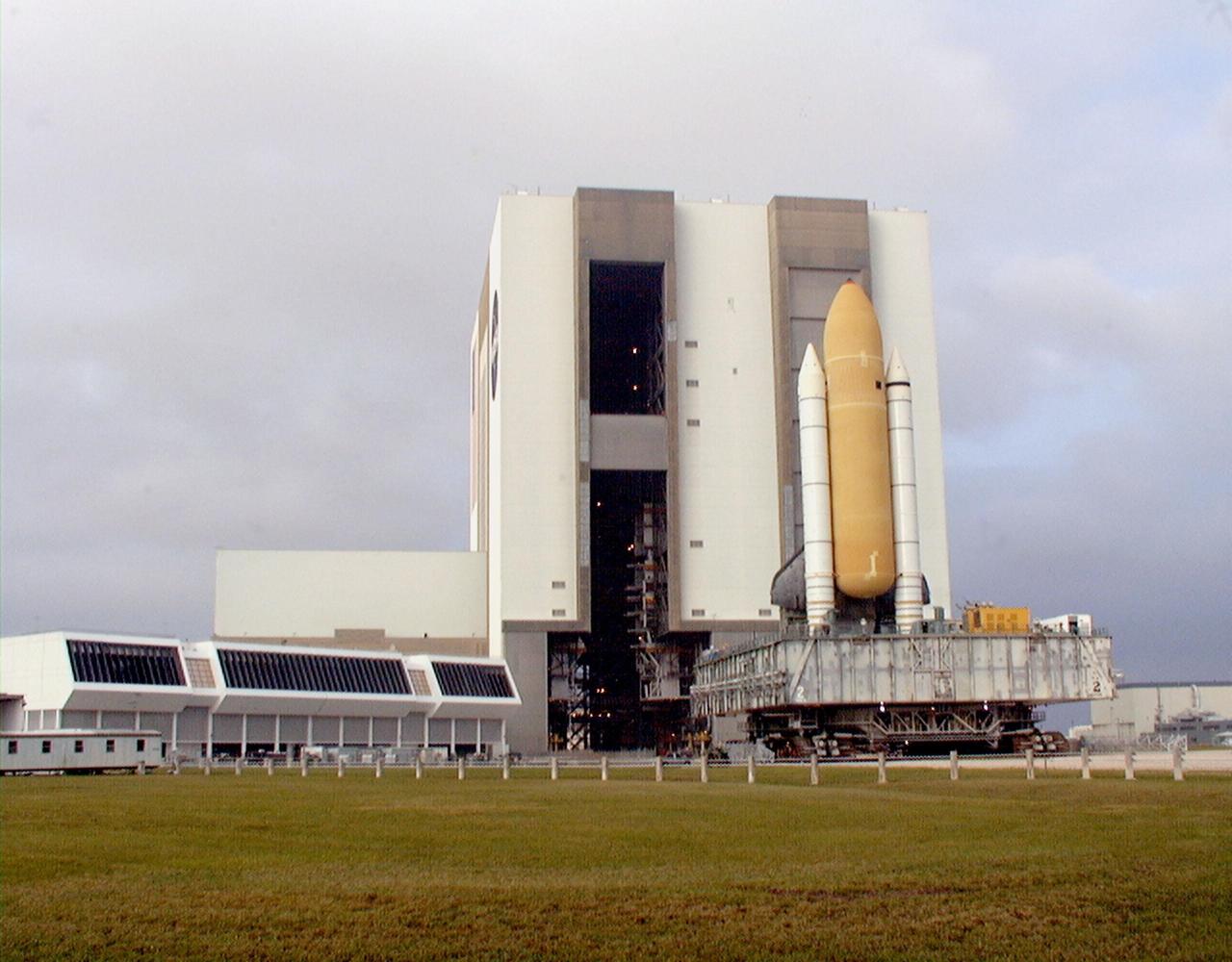 KENNEDY SPACE CENTER, FLA. -- Towering atop the mobile launcher platform and crawler transporter, Space Shuttle Discovery rolls out of the Vehicle Assembly Building on its way to Launch Pad 39B which is 4.2 miles (6.8 kilometers) away. While at the pad, the orbiter, external tank and solid rocket boosters will undergo final preparations for the STS-103 launch targeted for Dec. 6, 1999, at 2:37 a.m. EST. The mission is a "call-up" due to the need to replace portions of the pointing system the gyros which have begun to fail on the Hubble Space Telescope. Although Hubble is operating normally and conducting its scientific observations, only three of its six gyroscopes are working properly. The gyroscopes allow the telescope to point at stars, galaxies and planets. The STS-103 crew will also be installing a Fine Guidance Sensor, a new enhanced computer, a solid-state digital recorder, and a new spare transmitter to replace older equipment, and replacing degraded insulation on the telescope with new thermal insulation. The crew will also install a Battery Voltage/Temperature Improvement Kit to protect the spacecraft batteries from overcharging and overheating when the telescope goes into a safe mode. Four EVA's are planned to make the necessary repairs and replacements on the telescope. Comprising the STS-103 crew are Commander Curtis L. Brown Jr., Pilot Scott J. Kelly, Mission Specialist Steven L. Smith, Mission Specialist C. Michael Foale (Ph.D.), Mission Specialist John M. Grunsfeld (Ph.D.), Mission Specialist Claude Nicollier of Switzerland, with the European Space Agency, and Mission Specialist Jean-François Clervoy of France, with the European Space Agency