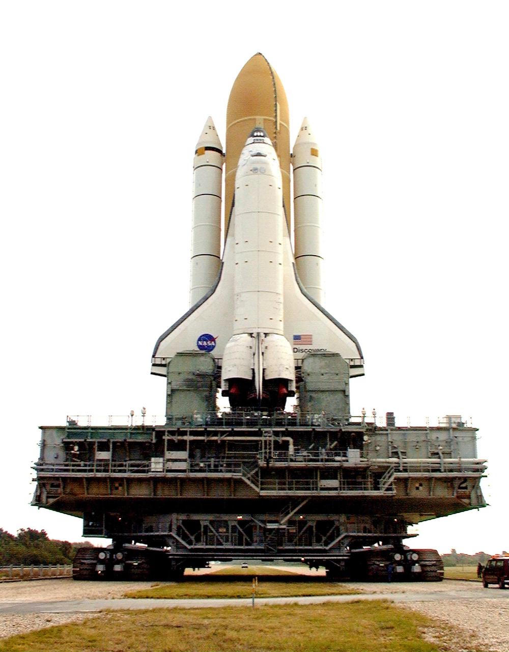KENNEDY SPACE CENTER, FLA. -- Towering atop the mobile launcher platform and crawler transporter, Space Shuttle Discovery makes its trek along the stretch of crawlerway between the Vehicle Assembly Building and Launch Pad 39B. Once at the pad, the orbiter, external tank and solid rocket boosters will undergo final preparations for the STS-103 launch targeted for Dec. 6, 1999, at 2:37 a.m. EST. The mission is a "call-up" due to the need to replace portions of the pointing system the gyros which have begun to fail on the Hubble Space Telescope. Although Hubble is operating normally and conducting its scientific observations, only three of its six gyroscopes are working properly. The gyroscopes allow the telescope to point at stars, galaxies and planets. The STS-103 crew will also be installing a Fine Guidance Sensor, a new enhanced computer, a solid-state digital recorder, and a new spare transmitter to replace older equipment, and replacing degraded insulation on the telescope with new thermal insulation. The crew will also install a Battery Voltage/Temperature Improvement Kit to protect the spacecraft batteries from overcharging and overheating when the telescope goes into a safe mode. Four EVA's are planned to make the necessary repairs and replacements on the telescope. Comprising the STS-103 crew are Commander Curtis L. Brown Jr., Pilot Scott J. Kelly, Mission Specialist Steven L. Smith, Mission Specialist C. Michael Foale (Ph.D.), Mission Specialist John M. Grunsfeld (Ph.D.), Mission Specialist Claude Nicollier of Switzerland, with the European Space Agency, and Mission Specialist Jean-François Clervoy of France, with the European Space Agency.
