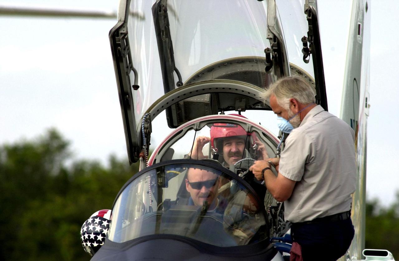A worker at the Shuttle Landing Facility checks over STS-103 Pilot Scott J. Kelly (front) and Mission Specialist John M. Grunsfeld (Ph.D.) (behind) before they take off for practice flights in the T-38 training jet. They and other crew members Commander Curtis L. Brown Jr. and Mission Specialists Steven L. Smith, C. Michael Foale (Ph.D.), Claude Nicollier of Switzerland and Jean-François Clervoy of France are preparing for their mission on Space Shuttle Discovery. STS-103 is scheduled for launch Dec. 16 at 9:18 p.m. EST from Launch Pad 39B. The mission is expected to last about 9 days and 21 hours. Discovery is expected to land at KSC Sunday, Dec. 26, at 6:56 p.m. EST