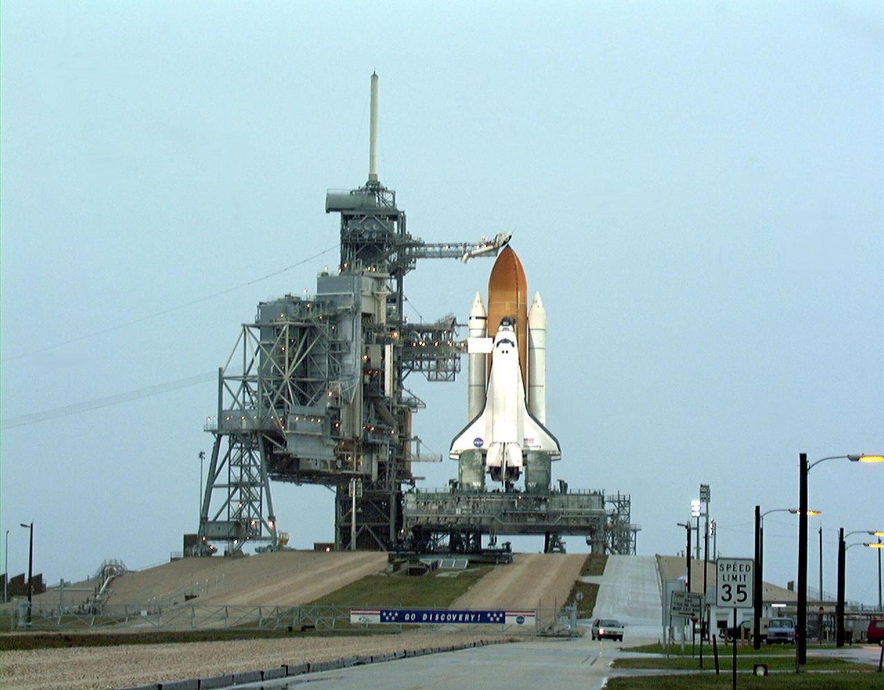 In the early morning at Launch Complex 39B, Space Shuttle Discovery stands ready for launch on mission STS-103 as rain falls all around it. Uncooperative weather also caused the scrub of a launch attempt Friday evening at about 8:52 p.m. EST. The STS-103 mission, to service the Hubble Space Telescope, is now scheduled for launch on Dec. 18 at 8:21 p.m. EST. Mission objectives include replacing gyroscopes and an old computer, installing a backup solid state recorder, and replacing damaged insulation on the telescope