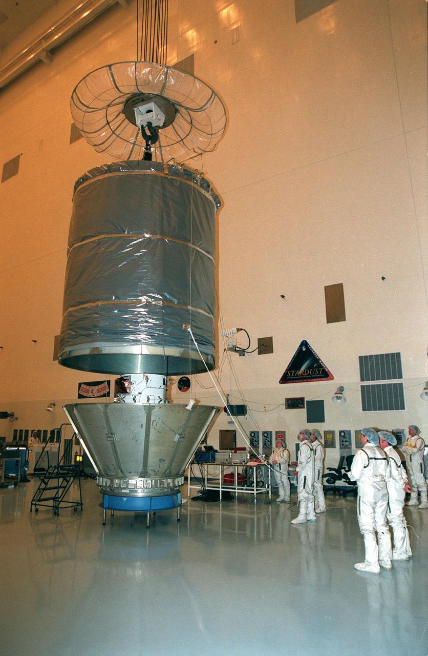 The cover is removed from the Stardust spacecraft in the Payload Hazardous Servicing Facility prior to a media presentation. Stardust is targeted for launch on Feb. 6 aboard a Boeing Delta II rocket from Launch Pad 17-A, Cape Canaveral Air Station. The spacecraft is destined for a close encounter with the comet Wild 2 in January 2004. Using a silicon-based substance called aerogel, Stardust will capture comet particles flying off the nucleus of the comet. The spacecraft also will bring back samples of interstellar dust. These materials consist of ancient pre-solar interstellar grains and other remnants left over from the formation of the solar system. Scientists expect their analysis to provide important insights into the evolution of the sun and planets and possibly into the origin of life itself. The collected samples will return to Earth in a sample return capsule (the white-topped, blunt-nosed cone seen on the top of the spacecraft) to be jettisoned as Stardust swings by Earth in January 2006