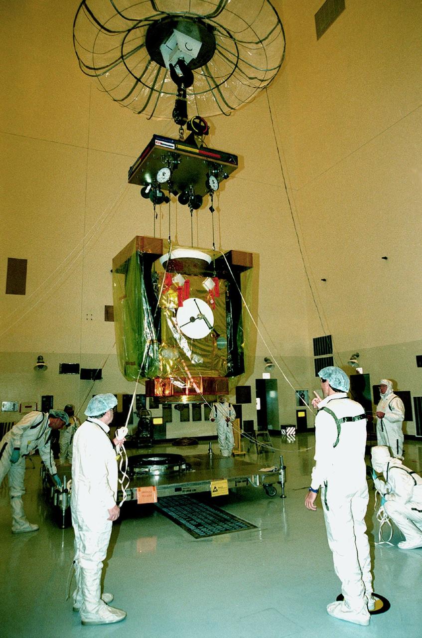 In the Payload Hazardous Servicing Facility, workers help guide the overhead crane lifting the Stardust spacecraft. Stardust is being moved in order to mate it with the third stage of a Boeing Delta II rocket. Targeted for launch Feb. 6 from Launch Pad 17-A, Cape Canaveral Air Station, aboard the Delta II rocket, the spacecraft is destined for a close encounter with the comet Wild 2 in January 2004. Using a silicon-based substance called aerogel, Stardust will capture comet particles flying off the nucleus of the comet. The spacecraft also will bring back samples of interstellar dust. These materials consist of ancient pre-solar interstellar grains and other remnants left over from the formation of the solar system. Scientists expect their analysis to provide important insights into the evolution of the sun and planets and possibly into the origin of life itself. The collected samples will return to Earth in a sample return capsule to be jettisoned as Stardust swings by Earth in January 2006