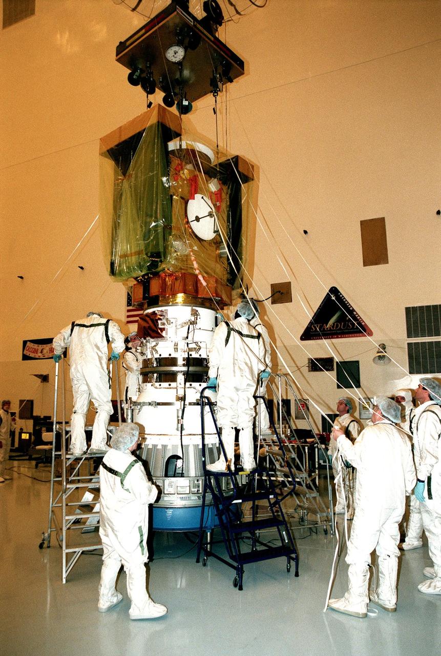 In the Payload Hazardous Servicing Facility, workers check the mating of the spacecraft Stardust (above) with the third stage of a Boeing Delta II rocket (below). Targeted for launch Feb. 6 from Launch Pad 17-A, Cape Canaveral Air Station, aboard the Delta II rocket, the spacecraft is destined for a close encounter with the comet Wild 2 in January 2004. Using a silicon-based substance called aerogel, Stardust will capture comet particles flying off the nucleus of the comet. The spacecraft also will bring back samples of interstellar dust. These materials consist of ancient pre-solar interstellar grains and other remnants left over from the formation of the solar system. Scientists expect their analysis to provide important insights into the evolution of the sun and planets and possibly into the origin of life itself. The collected samples will return to Earth in a sample return capsule to be jettisoned as Stardust swings by Earth in January 2006