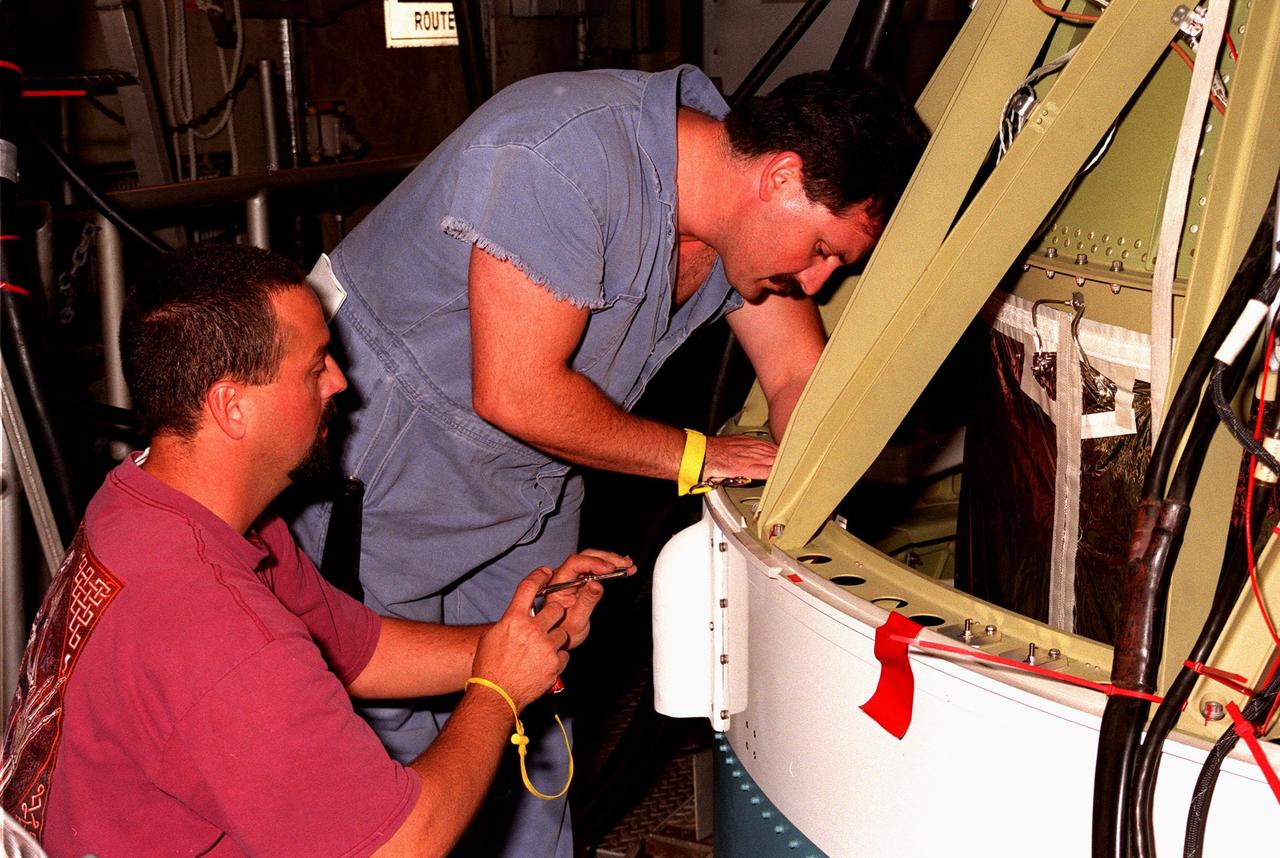 At Launch Pad 17-A, Cape Canaveral Air Station, workers check the mounting on a video camera on the second stage of a Boeing Delta II rocket that will launch the Stardust spacecraft on Feb. 6. Looking toward Earth, the camera will record the liftoff and separation of the first stage. Stardust is destined for a close encounter with the comet Wild 2 in January 2004. Using a silicon-based substance called aerogel, Stardust will capture comet particles flying off the nucleus of the comet. The spacecraft also will bring back samples of interstellar dust. These materials consist of ancient pre-solar interstellar grains and other remnants left over from the formation of the solar system. Scientists expect their analysis to provide important insights into the evolution of the sun and planets and possibly into the origin of life itself. The collected samples will return to Earth in a sample return capsule to be jettisoned as Stardust swings by Earth in January 2006