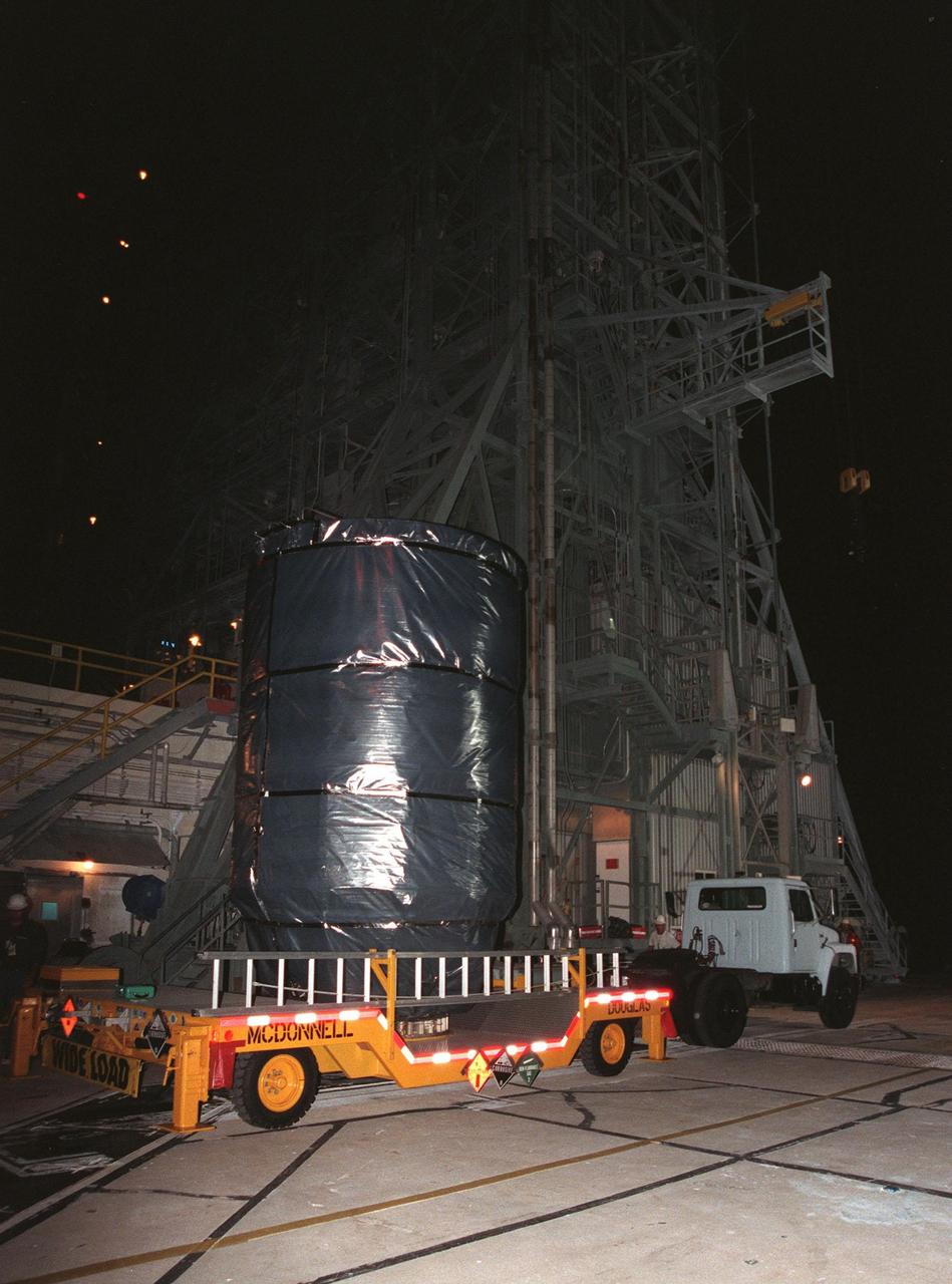 In the early morning, the Stardust spacecraft, with the third stage of a Boeing Delta II rocket attached, arrives atop a transporter at Launch Pad 17-A, Cape Canaveral Air Station. The second and third stages of the rocket will be mated and prepared for liftoff on Feb. 6. Stardust is destined for a close encounter with the comet Wild 2 in January 2004. Using a silicon-based substance called aerogel, Stardust will capture comet particles flying off the nucleus of the comet. The spacecraft also will bring back samples of interstellar dust. These materials consist of ancient pre-solar interstellar grains and other remnants left over from the formation of the solar system. Scientists expect their analysis to provide important insights into the evolution of the sun and planets and possibly into the origin of life itself. The collected samples will return to Earth in a sample return capsule to be jettisoned as Stardust swings by Earth in January 2006