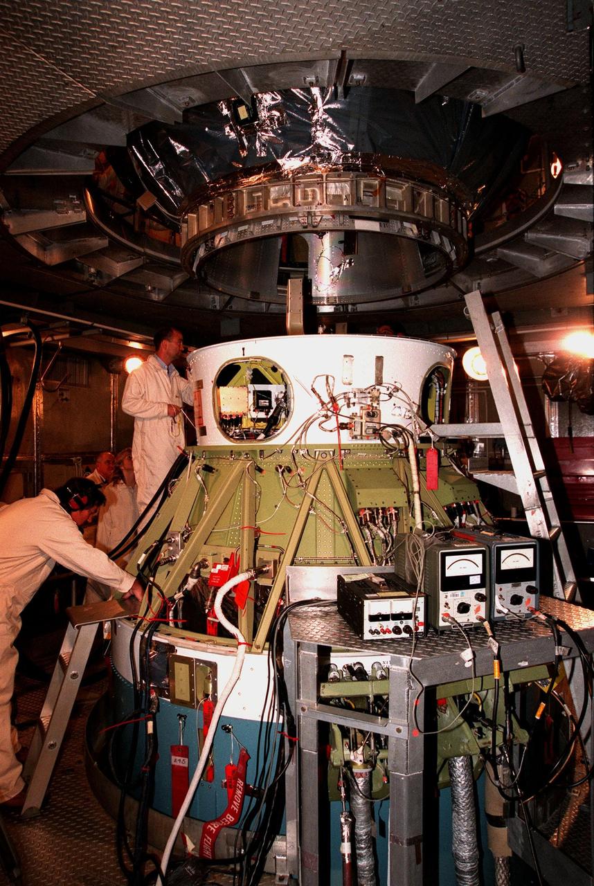 Workers inside the launch tower at Pad 17-A, Cape Canaveral Air Station, watch as the third stage of a Boeing Delta II rocket is lowered for mating with the second stage below it. The Stardust spacecraft, above it out of sight, is connected to the rocket's third stage. Stardust, targeted for liftoff on Feb. 6, is destined for a close encounter with the comet Wild 2 in January 2004. Using a silicon-based substance called aerogel, Stardust will capture comet particles flying off the nucleus of the comet. The spacecraft also will bring back samples of interstellar dust. These materials consist of ancient pre-solar interstellar grains and other remnants left over from the formation of the solar system. Scientists expect their analysis to provide important insights into the evolution of the sun and planets and possibly into the origin of life itself. The collected samples will return to Earth in a sample return capsule to be jettisoned as Stardust swings by Earth in January 2006