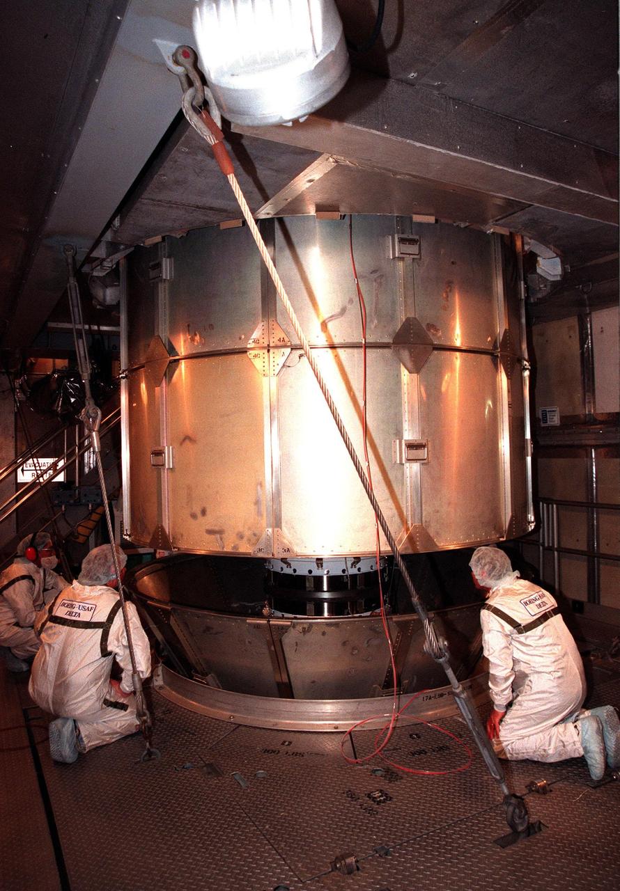 At Launch Pad 17-A, Cape Canaveral Air Station, workers watch as the protective canister is lifted from the Stardust spacecraft. Preparations continue for liftoff of the Boeing Delta II rocket carrying Stardust on Feb. 6. Stardust is destined for a close encounter with the comet Wild 2 in January 2004. Using a silicon-based substance called aerogel, Stardust will capture comet particles flying off the nucleus of the comet. The spacecraft also will bring back samples of interstellar dust. These materials consist of ancient pre-solar interstellar grains and other remnants left over from the formation of the solar system. Scientists expect their analysis to provide important insights into the evolution of the sun and planets and possibly into the origin of life itself. The collected samples will return to Earth in a sample return capsule to be jettisoned as Stardust swings by Earth in January 2006