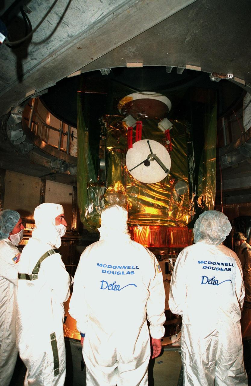 Workers watch as the protective canister surrounding the Stardust spacecraft is removed at Launch Pad 17-A, Cape Canaveral Air Station. Preparations continue for liftoff of the Boeing Delta II rocket carrying Stardust on Feb. 6. Stardust is destined for a close encounter with the comet Wild 2 in January 2004. Using a silicon-based substance called aerogel, Stardust will capture comet particles flying off the nucleus of the comet. The spacecraft also will bring back samples of interstellar dust. These materials consist of ancient pre-solar interstellar grains and other remnants left over from the formation of the solar system. Scientists expect their analysis to provide important insights into the evolution of the sun and planets and possibly into the origin of life itself. The collected samples will return to Earth in a sample return capsule to be jettisoned as Stardust swings by Earth in January 2006