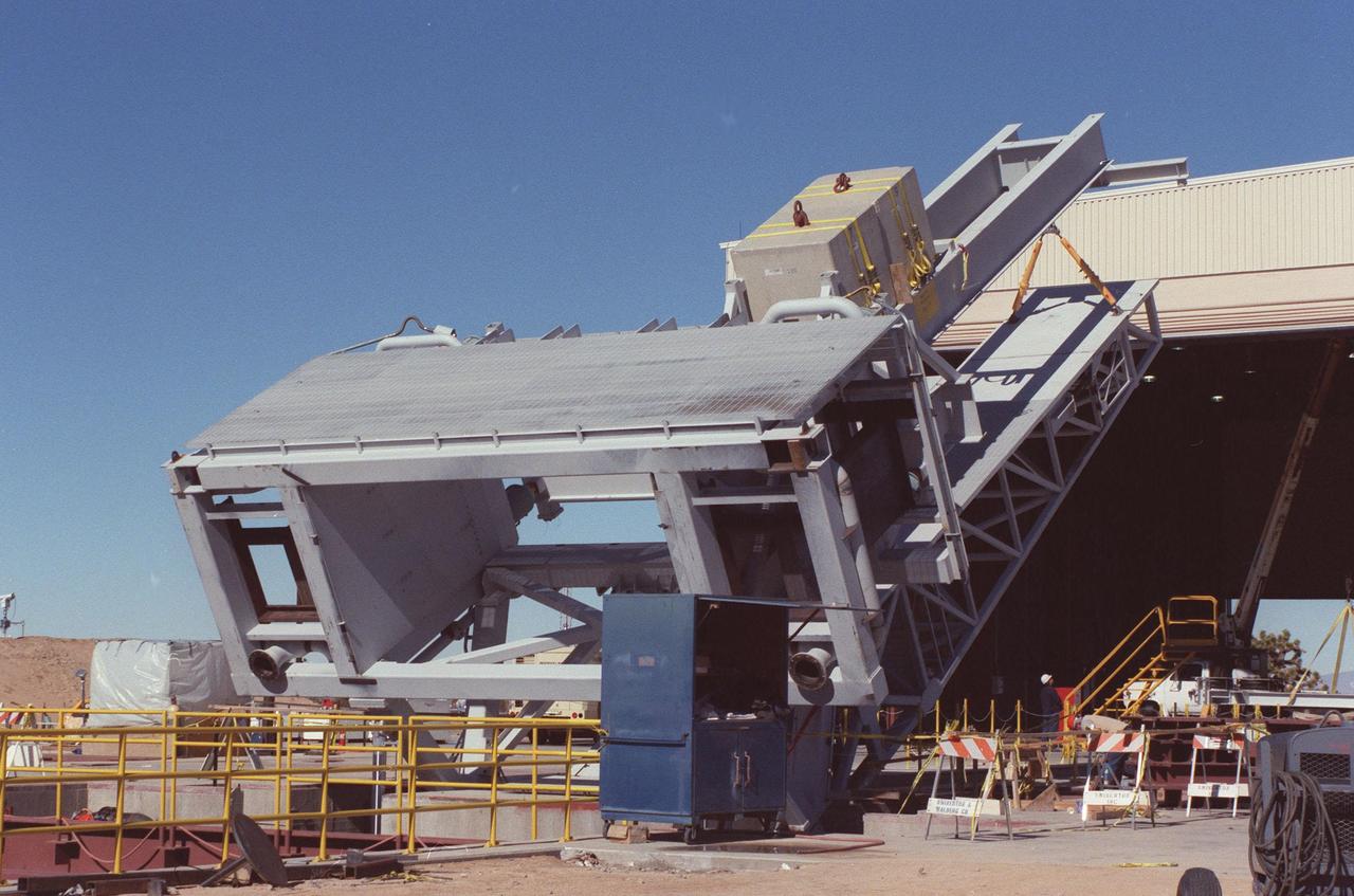The KSC-developed X-33 weight simulator (top), known as the "iron bird," is lifted to a vertical position at the X-33 launch site as part of launch equipment testing on Edwards Air Force Base, CA. The simulator matches the 75,000-pound weight and 63-foot height of the X-33 vehicle that will be using the launch equipment. KSC's Vehicle Positioning System (VPS) placed the simulator on the rotating launch platform prior to the rotation. The new VPS will dramatically reduce the amount of manual labor required to position a reusable launch vehicle for liftoff