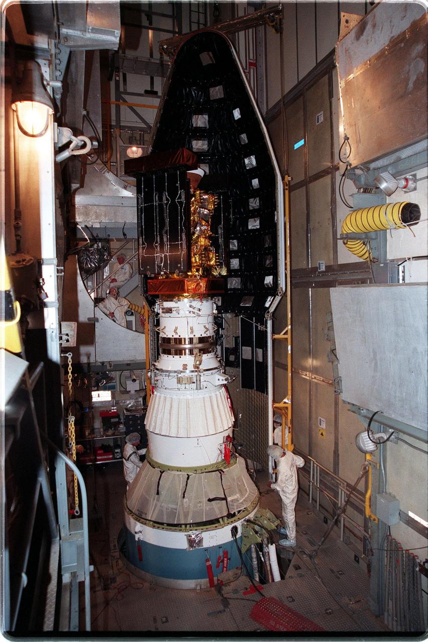 At Launch Pad 17-A, Cape Canaveral Air Station, workers begin placing the fairing around the Stardust spacecraft and upper stage of the Boeing Delta II rocket. Targeted for launch at 4:06:42 p.m. on Feb. 6, Stardust is destined for a close encounter with the comet Wild 2 in January 2004. Using a silicon-based substance called aerogel, Stardust will capture comet particles flying off the nucleus of the comet. The spacecraft also will bring back samples of interstellar dust. These materials consist of ancient pre-solar interstellar grains and other remnants left over from the formation of the solar system. Scientists expect their analysis to provide important insights into the evolution of the sun and planets and possibly into the origin of life itself. The collected samples will return to Earth in a sample return capsule to be jettisoned as Stardust swings by Earth in January 2006