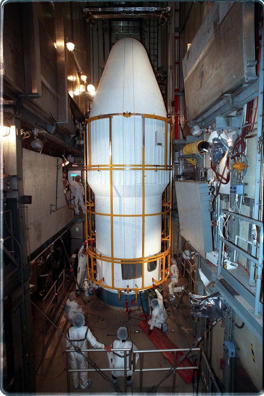 At Launch Pad 17-A, Cape Canaveral Air Station, workers check the lower fittings of the fairing installed around the Stardust spacecraft and upper stage of the Boeing Delta II rocket. Targeted for launch at 4:06:42 p.m. on Feb. 6, the spacecraft is destined for a close encounter with the comet Wild 2 in January 2004. Using a silicon-based substance called aerogel, Stardust will capture comet particles flying off the nucleus of the comet. The spacecraft also will bring back samples of interstellar dust. These materials consist of ancient pre-solar interstellar grains and other remnants left over from the formation of the solar system. Scientists expect their analysis to provide important insights into the evolution of the sun and planets and possibly into the origin of life itself. The collected samples will return to Earth in a sample return capsule to be jettisoned as Stardust swings by Earth in January 2006