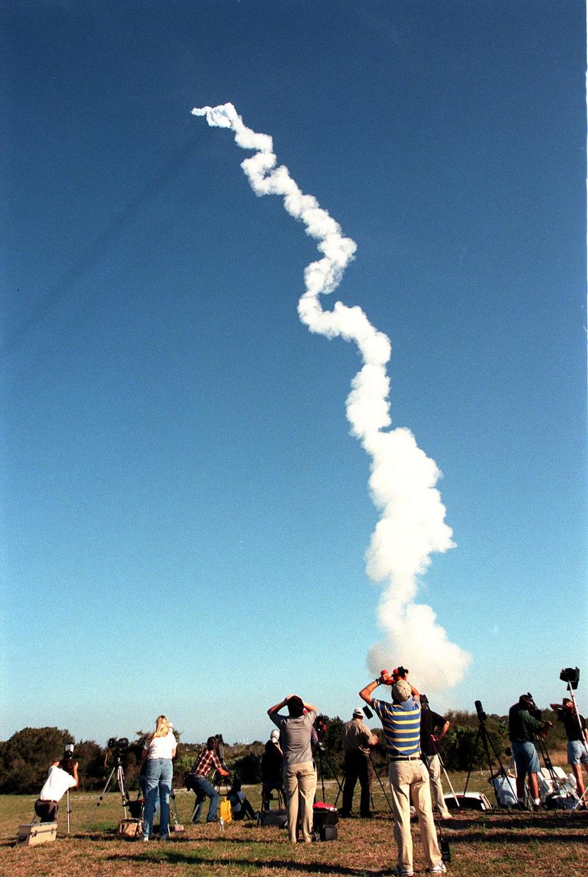 Photographers (left) and reporters (right) follow the snaking exhaust of the Boeing Delta II rocket carrying the Stardust spacecraft after its launch at 4:04:15 p.m. EST. A 24-hour scrub postponed the launch from the originally scheduled date of Feb. 6. Stardust is destined for a close encounter with the comet Wild 2 in January 2004. Using a silicon-based substance called aerogel, Stardust will capture comet particles flying off the nucleus of the comet. The spacecraft also will bring back samples of interstellar dust. These materials consist of ancient pre-solar interstellar grains and other remnants left over from the formation of the solar system. Scientists expect their analysis to provide important insights into the evolution of the sun and planets and possibly into the origin of life itself. The collected samples will return to Earth in a sample return capsule to be jettisoned as Stardust swings by Earth in January 2006