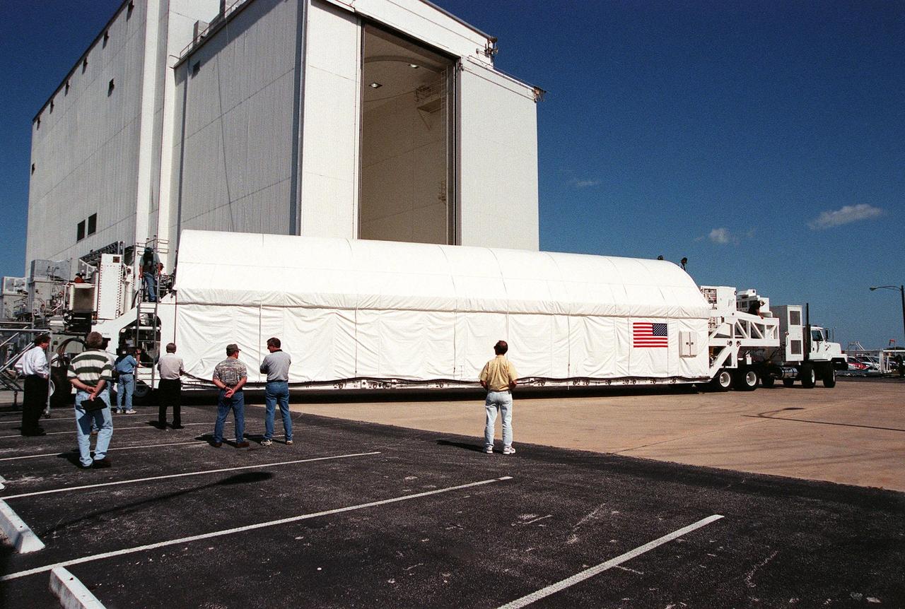 Cradled in the cargo hold of a tractor-trailer rig called the Space Cargo Transportation System, the Chandra X-ray Observatory reaches the Vertical Processing Facility (VPF). Chandra arrived at the Shuttle Landing Facility on Thursday, Feb. 4, aboard an Air Force C-5 Galaxy aircraft. In the VPF, the telescope will undergo final installation of associated electronic components; it will also be tested, fueled and mated with the Inertial Upper Stage booster. A set of integrated tests will follow. Chandra is scheduled for launch July 9 aboard Space Shuttle Columbia, on mission STS-93 . Formerly called the Advanced X-ray Astrophysics Facility, Chandra comprises three major elements: the spacecraft, the science instrument module (SIM), and the world's most powerful X-ray telescope. Chandra will allow scientists from around the world to see previously invisible black holes and high-temperature gas clouds, giving the observatory the potential to rewrite the books on the structure and evolution of our universe