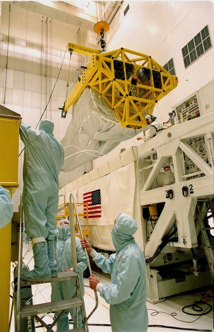In the Vertical Processing Facility (VPF), workers begin moving the overhead crane carrying the Chandra X-ray Observatory from its protective container to a stand on the floor. While in the VPF, the telescope will undergo final installation of associated electronic components; it will also be tested, fueled and mated with the Inertial Upper Stage booster. A set of integrated tests will follow. Chandra is scheduled for launch July 9 aboard Space Shuttle Columbia, on mission STS-93 . Formerly called the Advanced X-ray Astrophysics Facility, Chandra comprises three major elements: the spacecraft, the science instrument module (SIM), and the world's most powerful X-ray telescope. Chandra will allow scientists from around the world to see previously invisible black holes and high-temperature gas clouds, giving the observatory the potential to rewrite the books on the structure and evolution of our universe