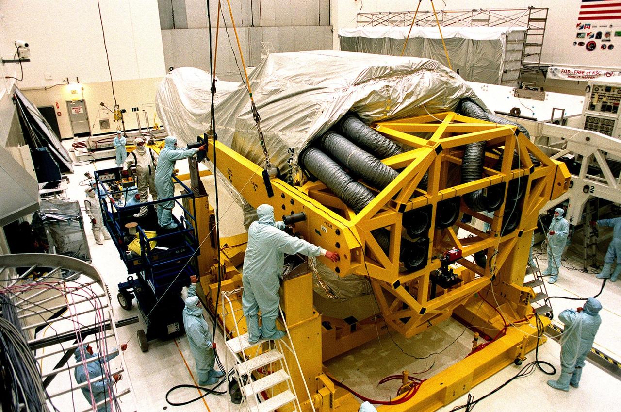 In the Vertical Processing Facility (VPF), workers check fittings and cables on the stand that will raise the Chandra X-ray Observatory to a vertical position. While in the VPF, the telescope will undergo final installation of associated electronic components; it will also be tested, fueled and mated with the Inertial Upper Stage booster. A set of integrated tests will follow. Chandra is scheduled for launch July 9 aboard Space Shuttle Columbia, on mission STS-93 . Formerly called the Advanced X-ray Astrophysics Facility, Chandra comprises three major elements: the spacecraft, the science instrument module (SIM), and the world's most powerful X-ray telescope. Chandra will allow scientists from around the world to see previously invisible black holes and high-temperature gas clouds, giving the observatory the potential to rewrite the books on the structure and evolution of our universe