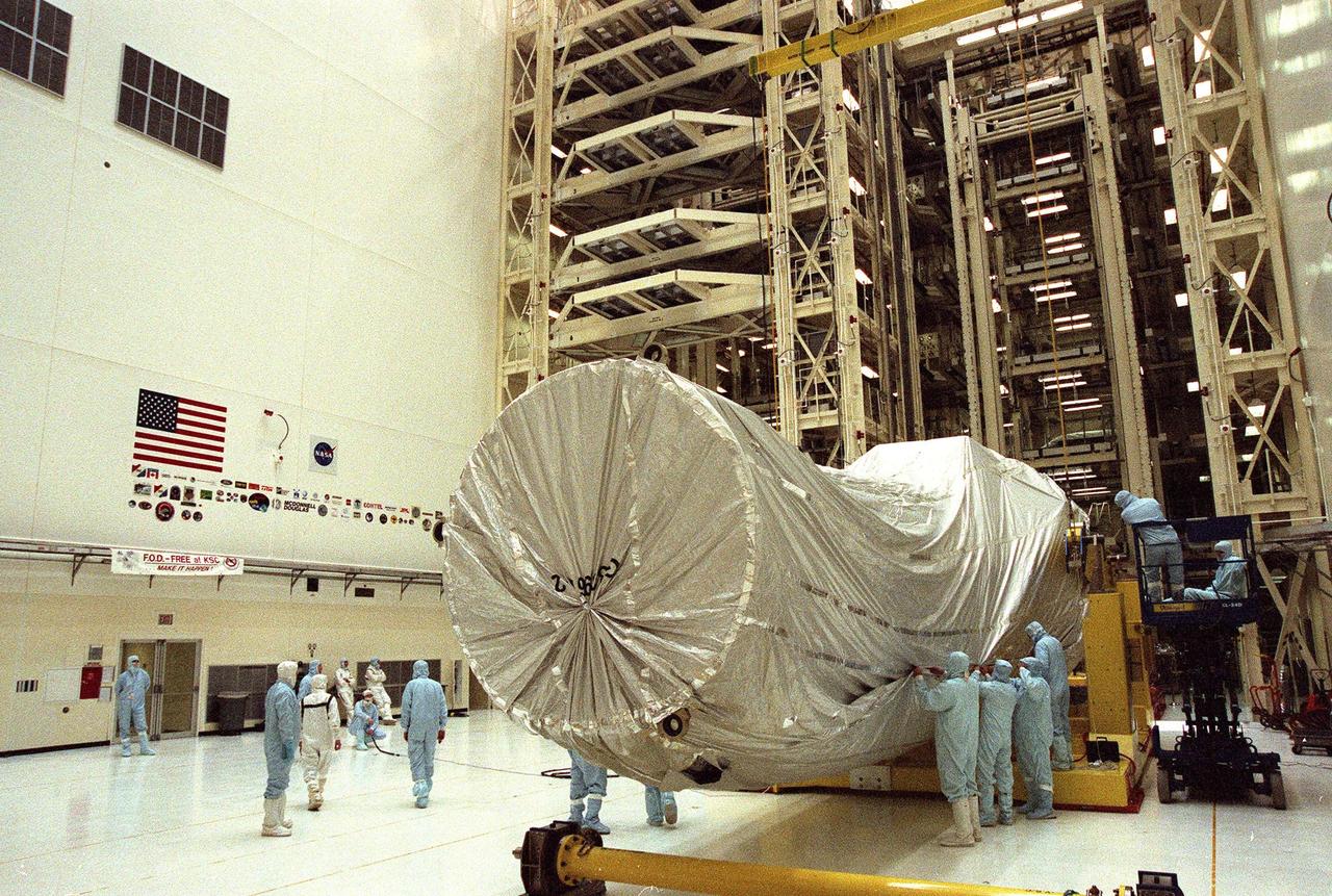 In the Vertical Processing Facility (VPF), workers prepare the shrouded Chandra X-ray Observatory for its lift to a vertical position. The telescope will undergo final installation of associated electronic components; it will also be tested, fueled and mated with the Inertial Upper Stage booster. A set of integrated tests will follow. Chandra is scheduled for launch July 9 aboard Space Shuttle Columbia, on mission STS-93 . Formerly called the Advanced X-ray Astrophysics Facility, Chandra comprises three major elements: the spacecraft, the science instrument module (SIM), and the world's most powerful X-ray telescope. Chandra will allow scientists from around the world to see previously invisible black holes and high-temperature gas clouds, giving the observatory the potential to rewrite the books on the structure and evolution of our universe