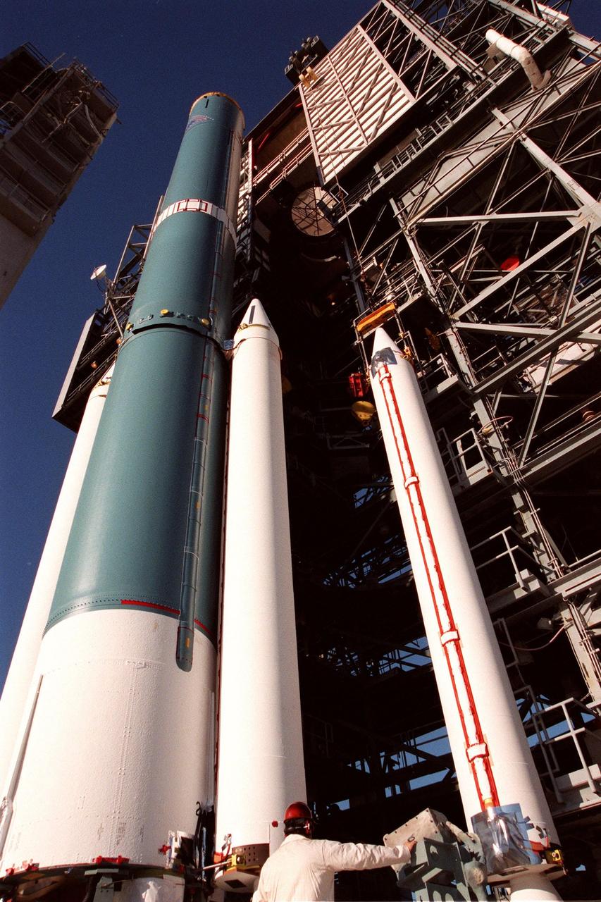 At Pad 17A, Cape Canaveral Air Station, a fourth and final solid rocket booster (SRB) (right) is moved from the mobile tower by a crane before mating with the Delta II rocket (left). The rocket will be aided by four SRBs to carry the Stardust satellite into space for a close encounter with the comet Wild 2 in January 2004. Using a medium called aerogel, Stardust will capture comet particles flying off the nucleus of the comet, plus collect interstellar dust for later analysis. The collected samples will return to Earth in a Sample Return Capsule to be jettisoned as Stardust swings by Earth in January 2006. Stardust is scheduled to be launched on Feb. 6, 1999