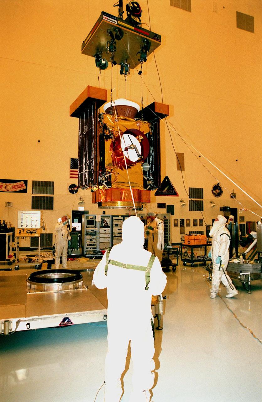 In the Payload Hazardous Servicing Facility, workers raise the <a href="http://www-pao.ksc.nasa.gov/kscpao/captions/subjects/stardust.htm"> Stardust</a> spacecraft from its workstand to move it to another area for lighting tests on the solar panels. Stardust is scheduled to be launched aboard a Boeing Delta II rocket from Launch Pad 17A, Cape Canaveral Air Station, on Feb. 6, 1999, for a rendezvous with the comet Wild 2 in January 2004. Stardust will use a substance called aerogel to capture comet particles flying off the nucleus of the comet, plus collect interstellar dust for later analysis. The collected samples will return to Earth in a sample return capsule to be jettisoned as it swings by Earth in January 2006