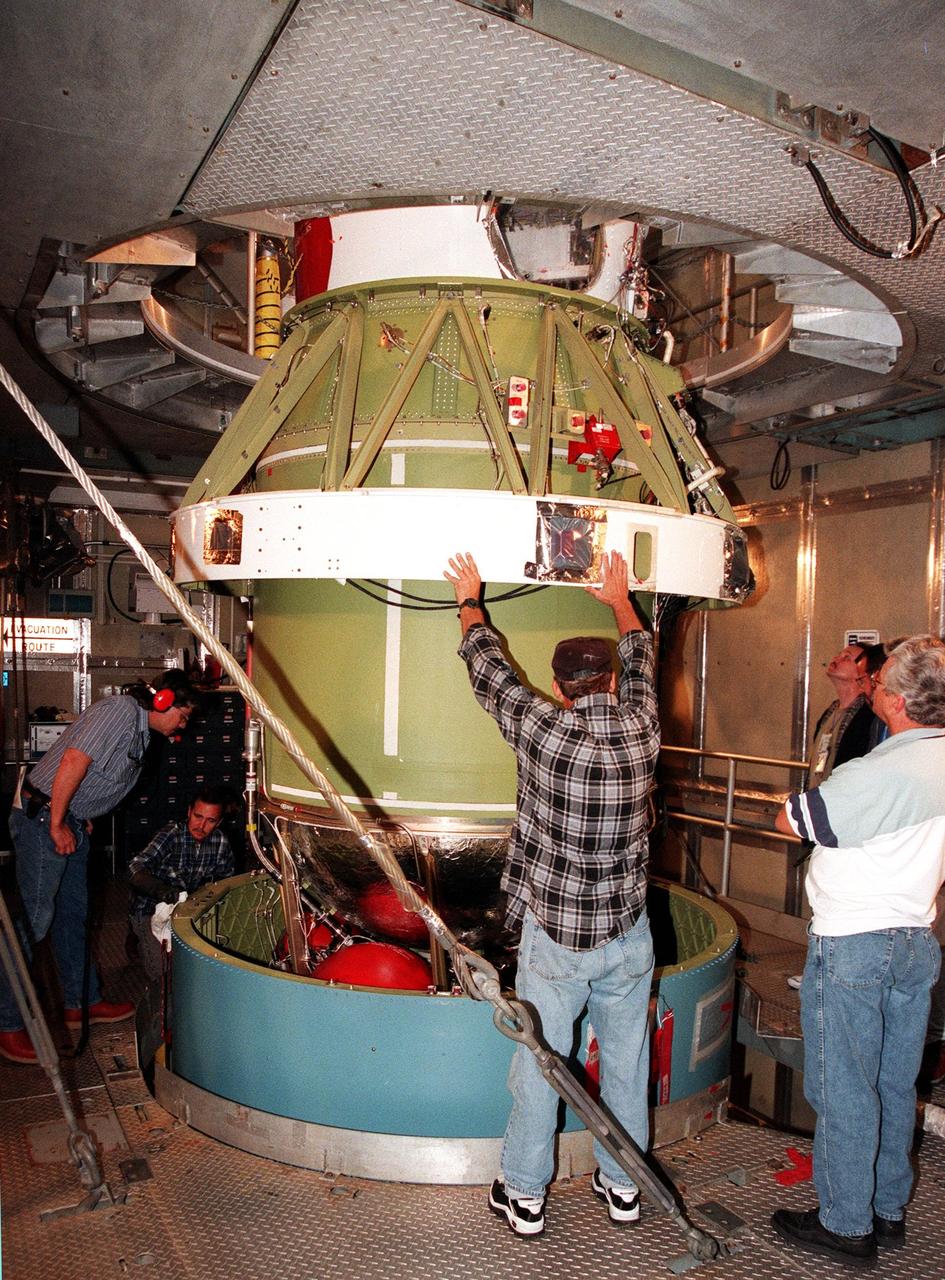 At Pad 17A, Cape Canaveral Air Station, a worker helps guide the second stage of a Boeing Delta II rocket as it is lowered for mating with the first stage. The rocket is targeted for launch on Feb. 6, carrying the <a href="http://www-pao.ksc.nasa.gov/kscpao/captions/subjects/stardust.htm">Stardust </a> spacecraft into space for a close encounter with the comet Wild 2 in January 2004. Using a substance called aerogel, Stardust will capture comet particles flying off the nucleus of the comet, plus collect interstellar dust for later analysis. The collected samples will return to Earth in a sample return capsule to be jettisoned as Stardust swings by Earth in January 2006