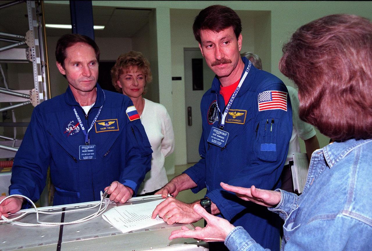 KENNEDY SPACE CENTER, FLA. -- In the SPACEHAB Facility, STS-96 Mission Specialist Valery Tokarev of Russia (left) and Commander Kent Rominger (second from right) listen to Lynn Ashby (far right), with JSC, talking about the SPACEHAB equipment in front of them during a payload Interface Verification Test (IVT). In the background behind Tokarev is TTI interpreter Valentina Maydell. Other STS-96 crew members at KSC for the IVT are Pilot Rick Husband and Mission Specialists Dan Barry, Ellen Ochoa, Tamara Jernigan and Julie Payette. Mission STS-96 carries the SPACEHAB Logistics Double Module, which will have equipment to further outfit the International Space Station service module and equipment that can be off-loaded from the early U.S. assembly flights. It carries internal logistics and resupply cargo for station outfitting, plus an external Russian cargo crane to be mounted to the exterior of the Russian station segment and used to perform space walking maintenance activities. The double module stowage provides capacity of up to 10,000 lbs. with the ability to accommodate powered payloads, four external rooftop stowage locations, four double-rack locations (two powered), up to 61 bulkhead-mounted middeck locker locations, and floor storage for large unique items and Soft Stowage. STS-96 is targeted to launch May 20 about 9:32 a.m