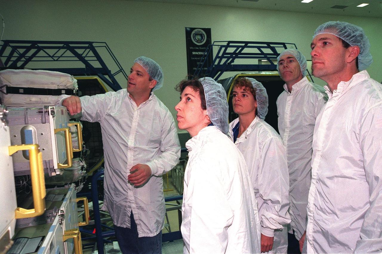 KENNEDY SPACE CENTER, FLA. -- In the SPACEHAB Facility, James Behling, with Boeing, talks about equipment for mission STS-96 during a payload Interface Verification Test (IVT). Watching are (from left) Mission Specialists Ellen Ochoa, Julie Payette and Dan Berry, and Pilot Rick Husband. Other STS-96 crew members at KSC for the IVT are Commander Kent Rominger and Mission Specialists Tamara Jernigan and Valery Tokarev of Russia. Mission STS-96 carries the SPACEHAB Logistics Double Module, which will have equipment to further outfit the International Space Station service module and equipment that can be off-loaded from the early U.S. assembly flights. It carries internal logistics and resupply cargo for station outfitting, plus an external Russian cargo crane to be mounted to the exterior of the Russian station segment and used to perform space walking maintenance activities. The double module stowage provides capacity of up to 10,000 lbs. with the ability to accommodate powered payloads, four external rooftop stowage locations, four double-rack locations (two powered), up to 61 bulkhead-mounted middeck locker locations, and floor storage for large unique items and Soft Stowage. STS-96 is targeted to launch May 20 about 9:32 a.m