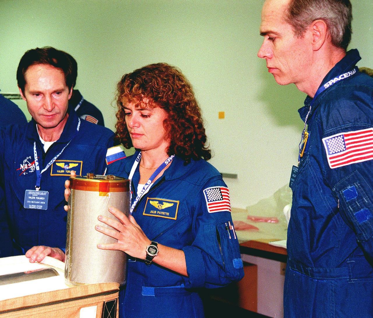 KENNEDY SPACE CENTER, FLA. -- In the SPACEHAB Facility for a payload Interface Verification Test (IVT) for their upcoming mission to the International Space Station are (left to right) Mission Specialists Valery Tokarev, Julie Payette (holding a lithium hydroxide canister) and Dan Barry. Other crew members at KSC for the IVT are Commander Kent Rominger, Pilot Rick Husband and Mission Specialists Ellen Ochoa and Tamara Jernigan. Mission STS-96 carries the SPACEHAB Logistics Double Module, which has equipment to further outfit the International Space Station service module and equipment that can be off-loaded from the early U.S. assembly flights. The SPACEHAB carries internal logistics and resupply cargo for station outfitting, plus an external Russian cargo crane to be mounted to the exterior of the Russian station segment and used to perform space walking maintenance activities. The double module stowage provides capacity of up to 10,000 lbs. with the ability to accommodate powered payloads, four external rooftop stowage locations, four double-rack locations (two powered), up to 61 bulkhead-mounted middeck locker locations, and floor storage for large unique items and Soft Stowage. STS-96 is targeted to launch May 20 about 9:32 a.m