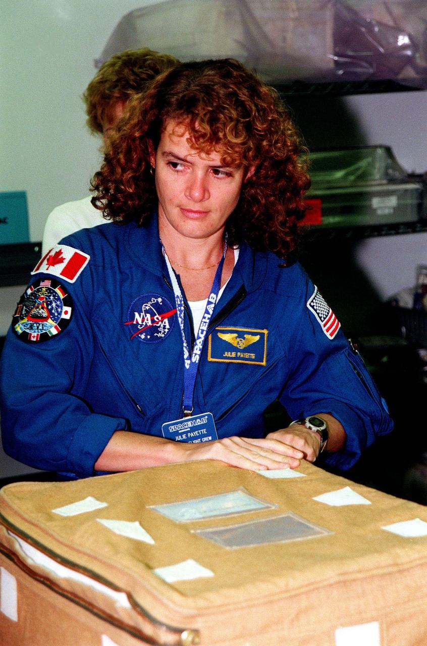 KENNEDY SPACE CENTER, FLA. -- In the SPACEHAB Facility, STS-96 Mission Specialist Julie Payette closes a container, part of the equipment to be carried on the SPACEHAB and mission STS-96. She and other crew members Commander Kent Rominger, Pilot Rick Husband, and Mission Speciaists Ellen Ochoa, Tamara Jernigan, Dan Barry and Valery Tokarev of Russia are at KSC for a payload Interface Verification Test for the upcoming mission to the International Space Station . Mission STS-96 carries the SPACEHAB Logistics Double Module, which has equipment to further outfit the International Space Station service module and equipment that can be off-loaded from the early U.S. assembly flights. The SPACEHAB carries internal logistics and resupply cargo for station outfitting, plus an external Russian cargo crane to be mounted to the exterior of the Russian station segment and used to perform space walking maintenance activities. The double module stowage provides capacity of up to 10,000 lbs. with the ability to accommodate powered payloads, four external rooftop stowage locations, four double-rack locations (two powered), up to 61 bulkhead-mounted middeck locker locations, and floor storage for large unique items and Soft Stowage. STS-96 is targeted to launch May 20 about 9:32 a.m