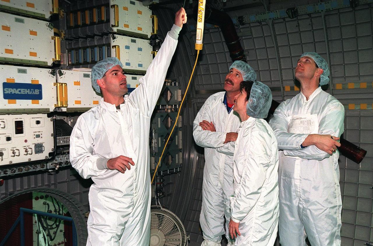 KENNEDY SPACE CENTER, FLA. -- During a payload Interface Verification Test (IVT) for the upcoming mission to the International Space Station , Chris Jaskolka of Boeing points out a piece of equipment in the SPACEHAB module to STS-96 Commander Kent Rominger, Mission Specialist Ellen Ochoa and Pilot Rick Husband. Other crew members visiting KSC for the IVT are Mission Specialists Tamara Jernigan, Dan Barry, Julie Payette and Valery Tokarev of Russia. Mission STS-96 carries the SPACEHAB Logistics Double Module, which will have equipment to further outfit the International Space Station service module and equipment that can be off-loaded from the early U.S. assembly flights. It carries internal logistics and resupply cargo for station outfitting, plus an external Russian cargo crane to be mounted to the exterior of the Russian station segment and used to perform space walking maintenance activities. The double module stowage provides capacity of up to 10,000 lbs. with the ability to accommodate powered payloads, four external rooftop stowage locations, four double-rack locations (two powered), up to 61 bulkhead-mounted middeck locker locations, and floor storage for large unique items and Soft Stowage. STS-96 is targeted to launch May 20 about 9:32 a.m. EDT