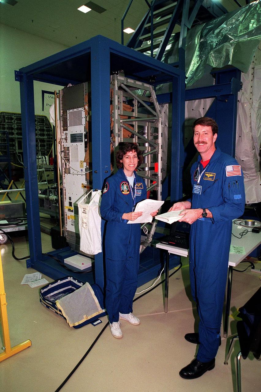 At the SPACEHAB Facility, STS-96 Mission Specialist Ellen Ochoa and Commander Kent Rominger pause during a payload Interface Verification Test (IVT) for their upcoming mission to the International Space Station. Other crew members at KSC for the IVT are Pilot Rick Husband and Mission Specialists Tamara Jernigan, Dan Barry, Julie Payette and Valery Tokarev of Russia. Mission STS-96 carries the SPACEHAB Logistics Double Module, which will have equipment to further outfit the International Space Station service module and equipment that can be off-loaded from the early U.S. assembly flights. It carries internal logistics and resupply cargo for station outfitting, plus an external Russian cargo crane to be mounted to the exterior of the Russian station segment and used to perform space walking maintenance activities. The double module stowage provides capacity of up to 10,000 lbs. with the ability to accommodate powered payloads, four external rooftop stowage locations, four double-rack locations (two powered), up to 61 bulkhead-mounted middeck locker locations, and floor storage for large unique items and Soft Stowage. STS-96 is targeted to launch May 20 about 9:32 a.m. EDT