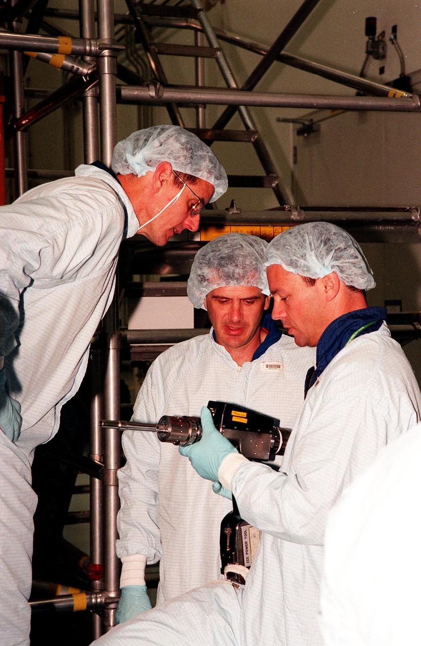 In the Space Station Processing Facility, members of the STS-92 crew become familiar with equipment in preparation for their mission to the International Space Station (ISS). STS-92 is targeted for launch in December 1999. From left are Mission Specialists Bill McArthur, Jeff Wisoff and Michael Lopez-Alegria, holding an ISS power tool. Other crew members visiting KSC are Commander Brian Duffy and Mission Specialists Koichi Wakata and Leroy Chiao. STS-92 is the fourth U.S. flight for construction of the International Space Station. The payload includes an integrated truss structure and a pressurized mating adapter