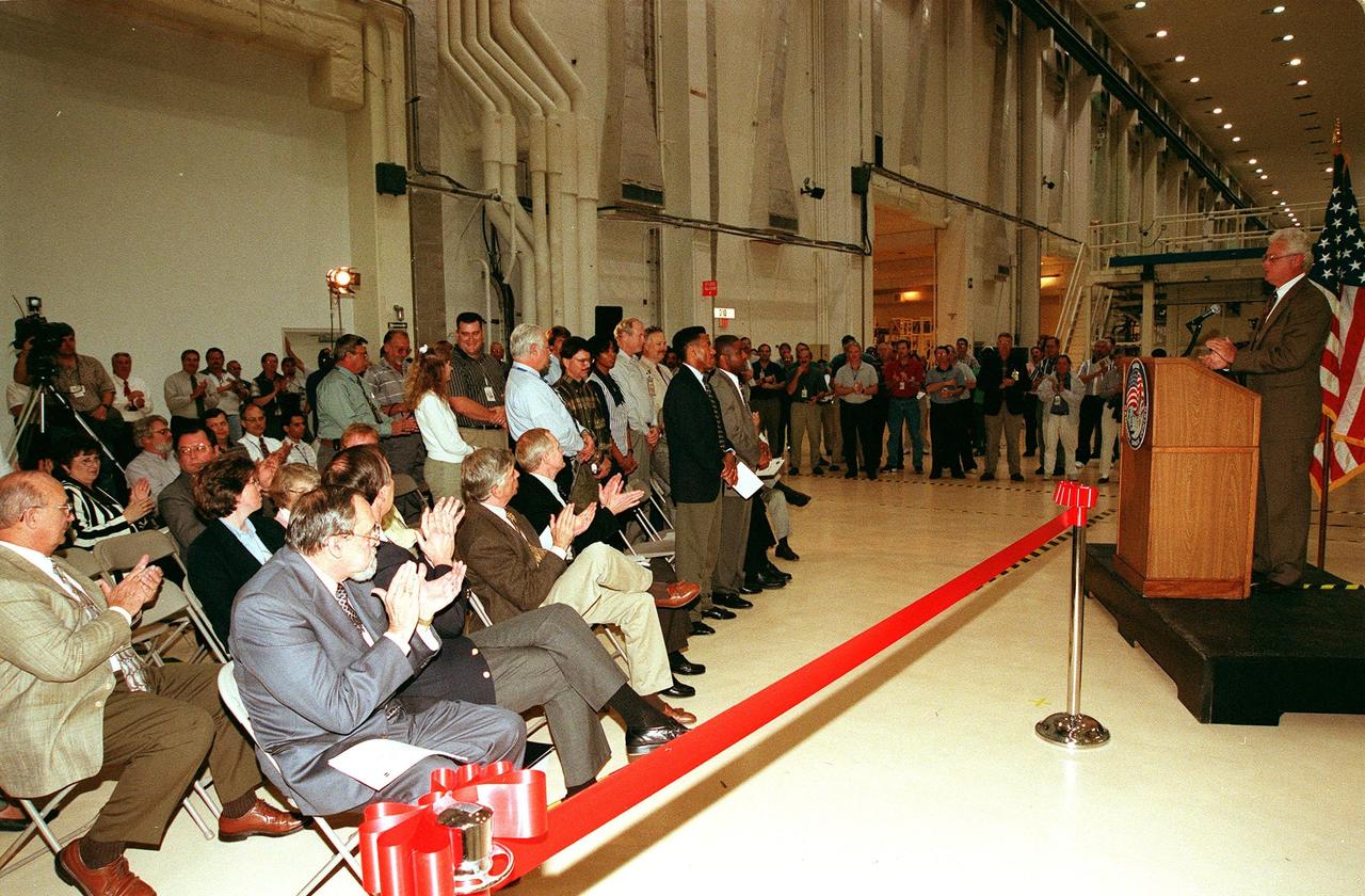 KENNEDY SPACE CENTER, FLA. -- At a ribbon-cutting ceremony inside the Operations and Checkout Building high bay, Sterling Walker, director of Engineering Development, introduces the project team members responsible for renovating an altitude chamber formerly used on the Apollo program. In addition, management, media and onlookers are present for the ceremony. Seated in the front row left are (left to right) Terry Smith, director of Engineering, Boeing Space Coast Operations; Steve Francois, director, Space Station and Shuttle Payloads; Jay Greene, International Space Station manager for Technical; and Roy Bridges, center director. The chamber was reactivated, after a 24-year hiatus, to perform leak tests on International Space Station pressurized modules at the launch site. Originally, two chambers were built to test the Apollo command and lunar service modules. They were last used in 1975 during the Apollo-Soyuz Test Project. After installation of new vacuum pumping equipment and controls, a new control room, and a new rotation handling fixture, the chamber again became operational in February 1999. The chamber, which is 33 feet in diameter and 50 feet tall, is constructed of stainless steel. The first module that will be tested for leaks is the U.S. Laboratory. No date has been determined for the test
